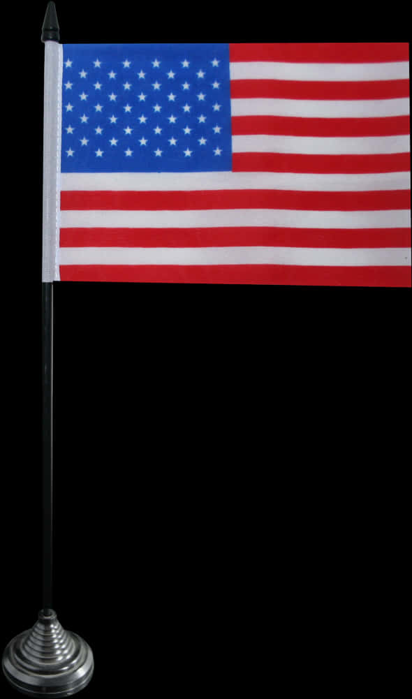 USA Flag 桌布 壁紙 — 一面小型美國國旗插在黑色旗桿上，銀色底座，背景為純黑色。