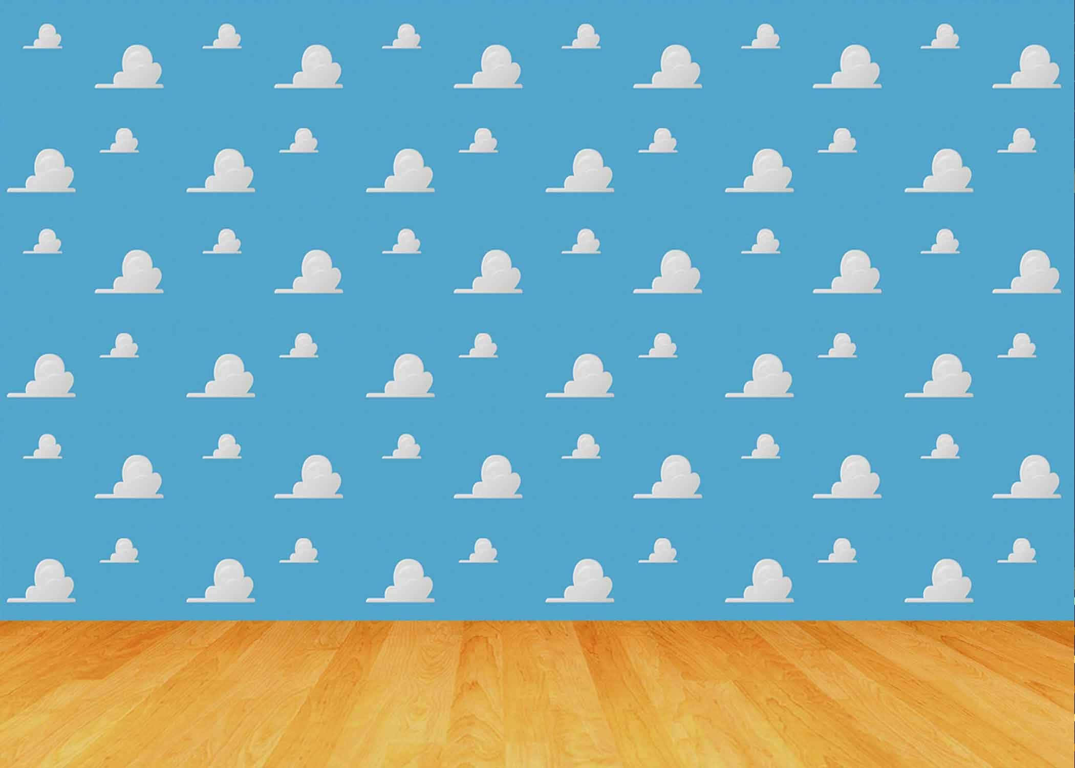 Toy Story Cloud 桌布 壁紙 — 一面明亮的藍色牆壁，飾有白色雲朵貼紙，與簡約房間內的溫暖木地板相遇。