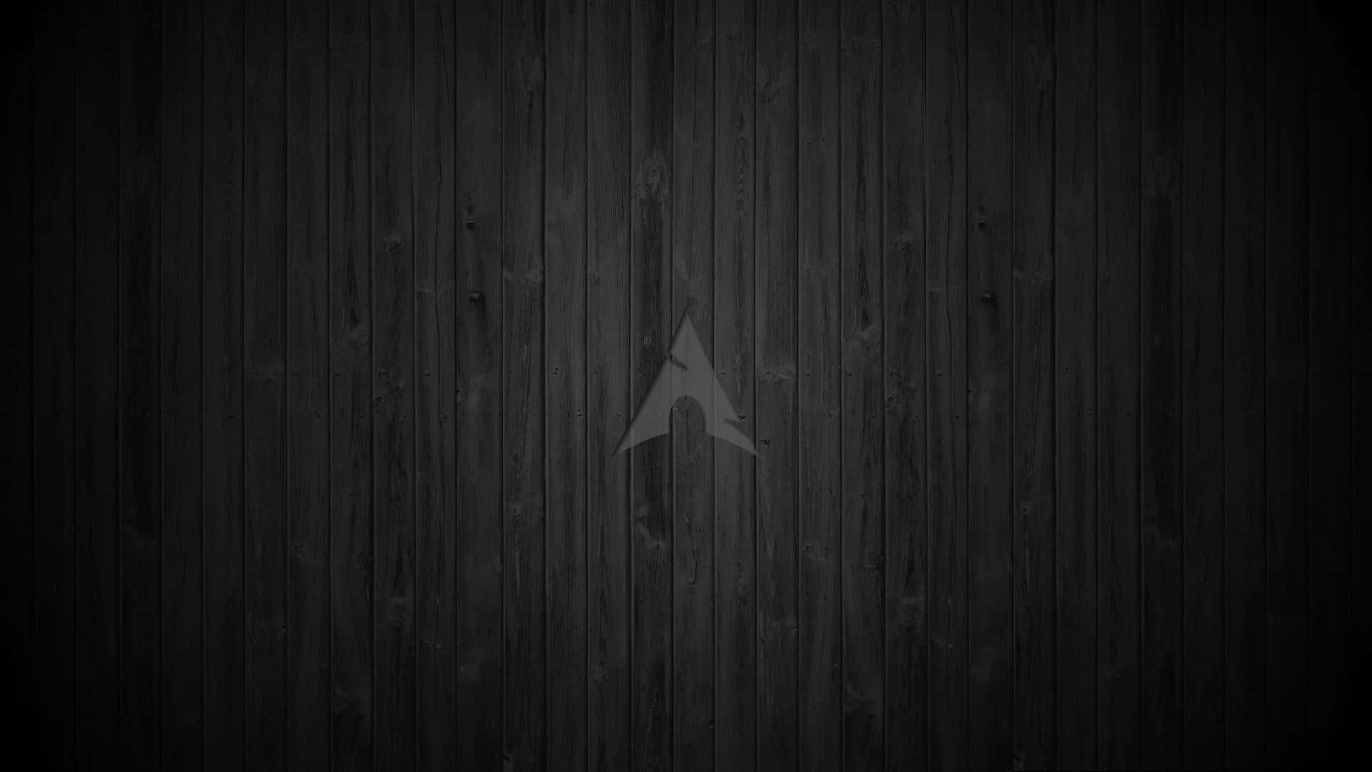 Arch Linux 桌布 壁紙 — 一面極簡風格的深色木牆，中央刻有微妙的灰色箭頭。