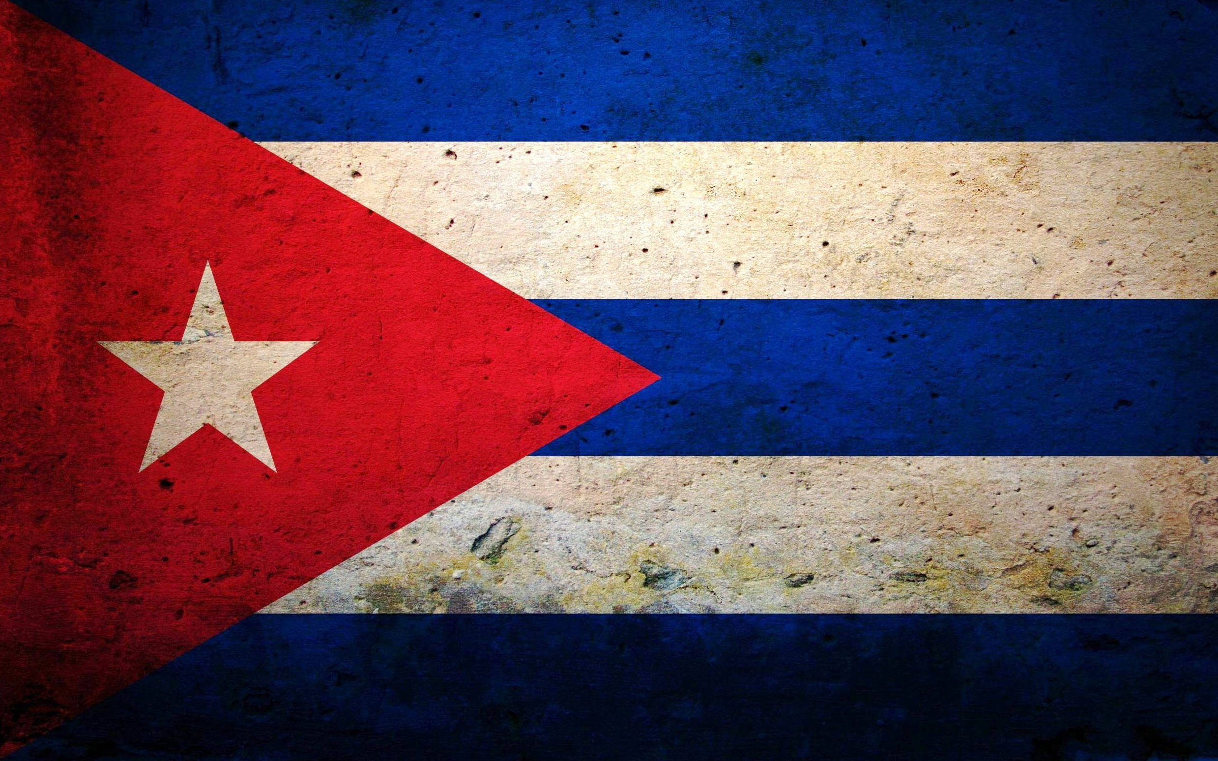 Cuban 桌布 壁紙 — 一面歷經風霜的古巴國旗，帶有紅、白、藍條紋，紅色三角形上有一顆白色星星，顯示出歲月和磨損的痕跡。