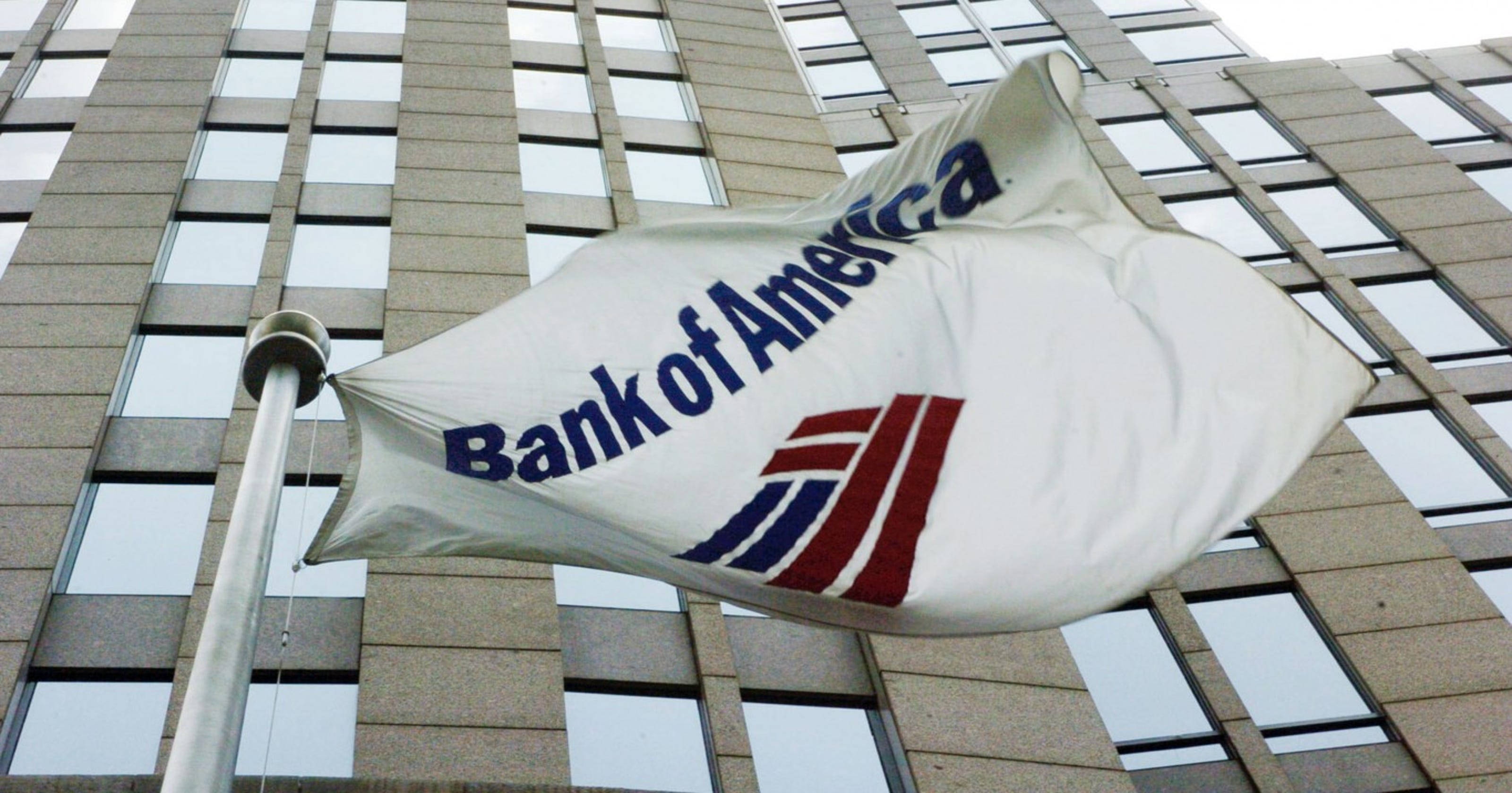 Bank 桌布 壁紙 — 一面白色的美國銀行旗幟在現代玻璃和石材摩天大樓外牆前飄揚。