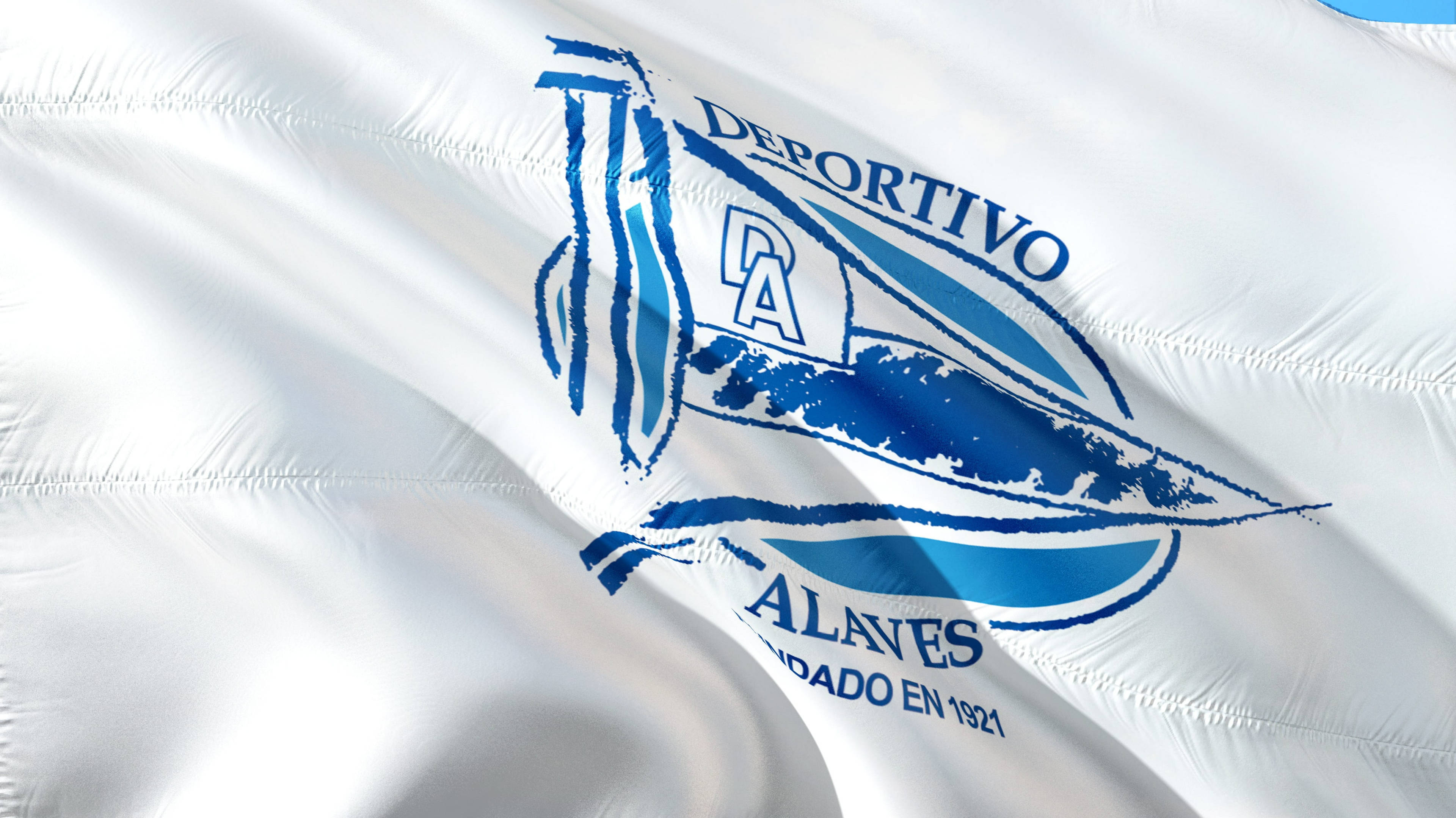 La 桌布 壁紙 — 一面白色絎縫旗幟，帶有藍色Deportivo Alavés標誌，隨風飄揚，顯示球隊名稱和成立年份1921年。