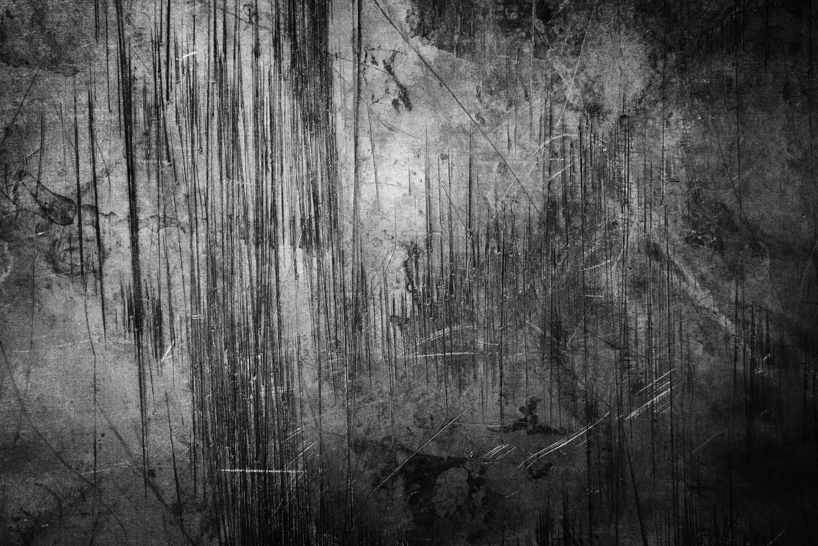 Grunge Texture 桌布 壁紙 — 一面粗糙的單色牆壁，帶有深深的刮痕和磨損的紋理，營造出原始的工業美學。