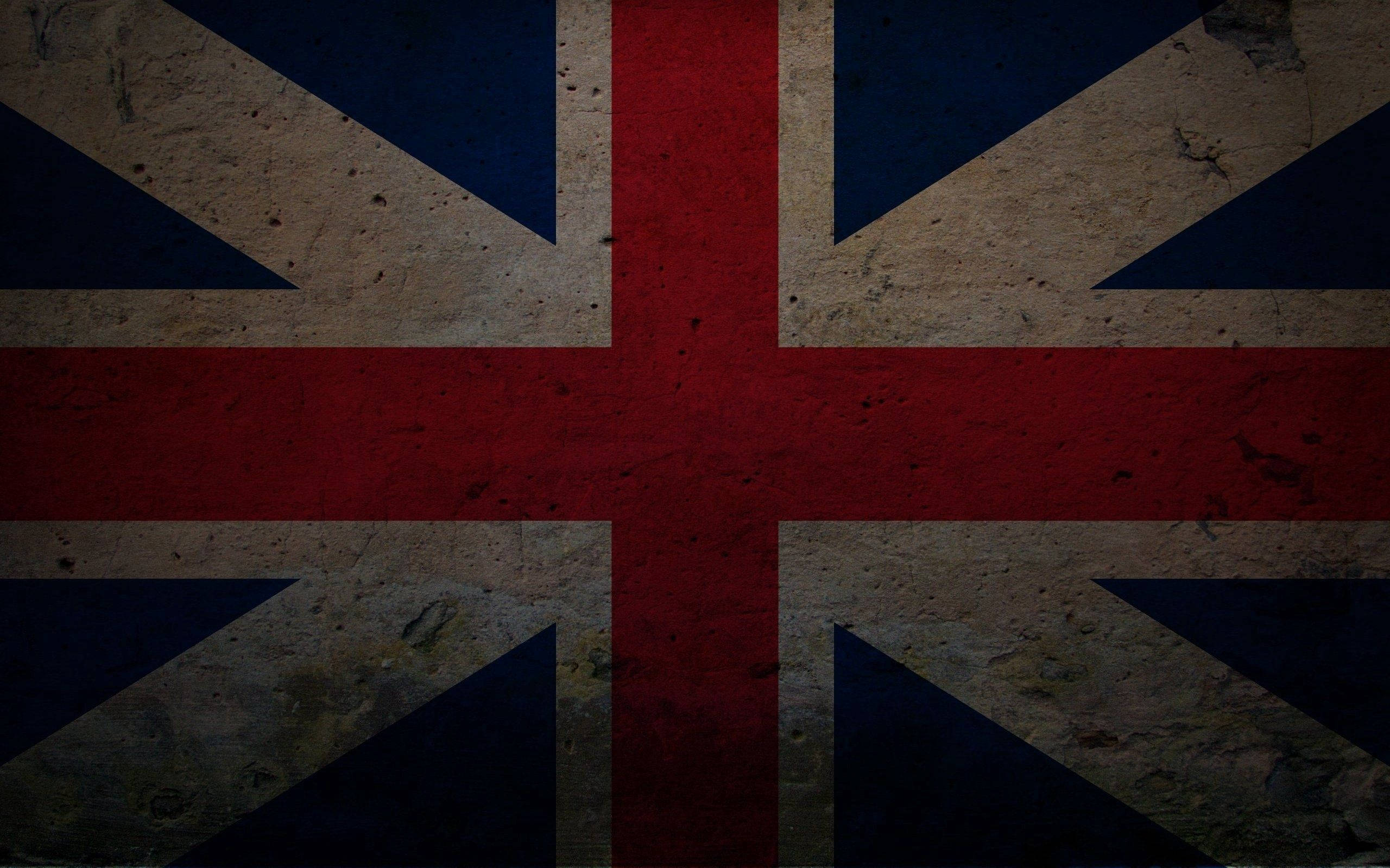 England 桌布 壁紙 — 一面經風化且帶有紋理的英國國旗，褪色的紅、藍和米色色調顯示出歲月和磨損的痕跡。