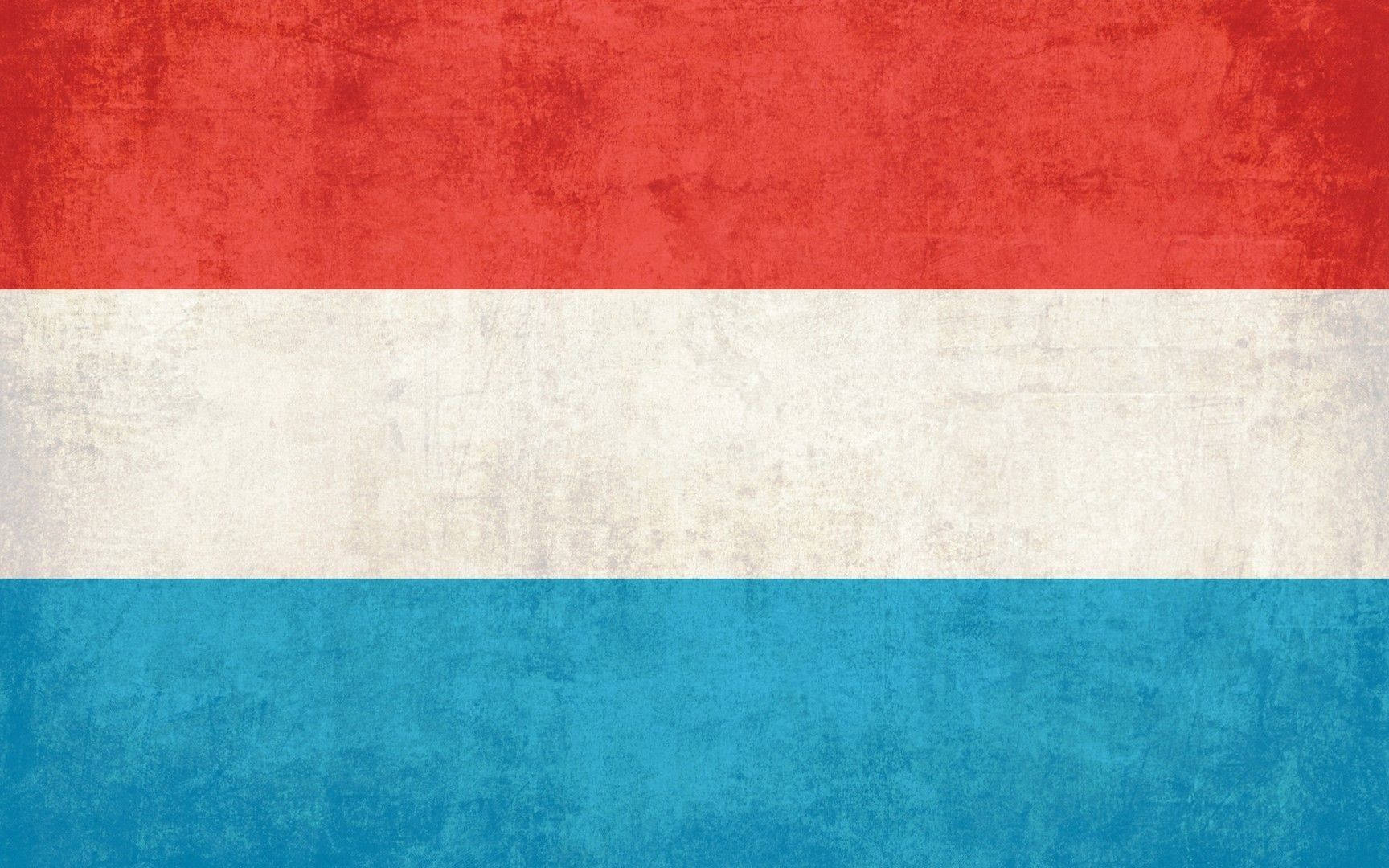 Luxembourg 桌布 壁紙 — 一面經風化的旗幟，帶有紅、白、藍橫條紋，顯示出紋理織物、褪色和可見的磨損。