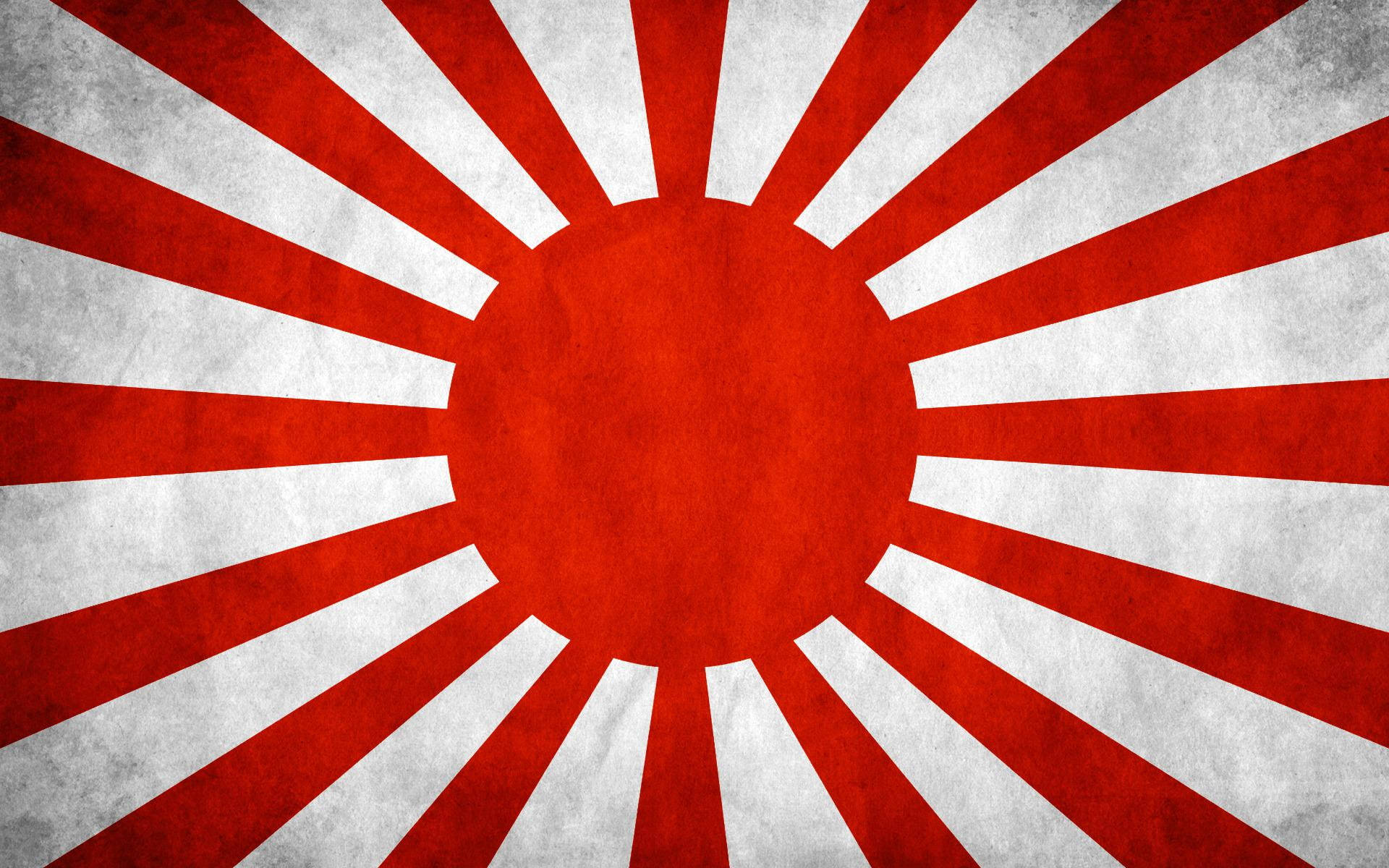 日式 桌布 壁紙 — 一面經風化的日本旭日旗，從紋理中心放射出大膽的紅白光芒。