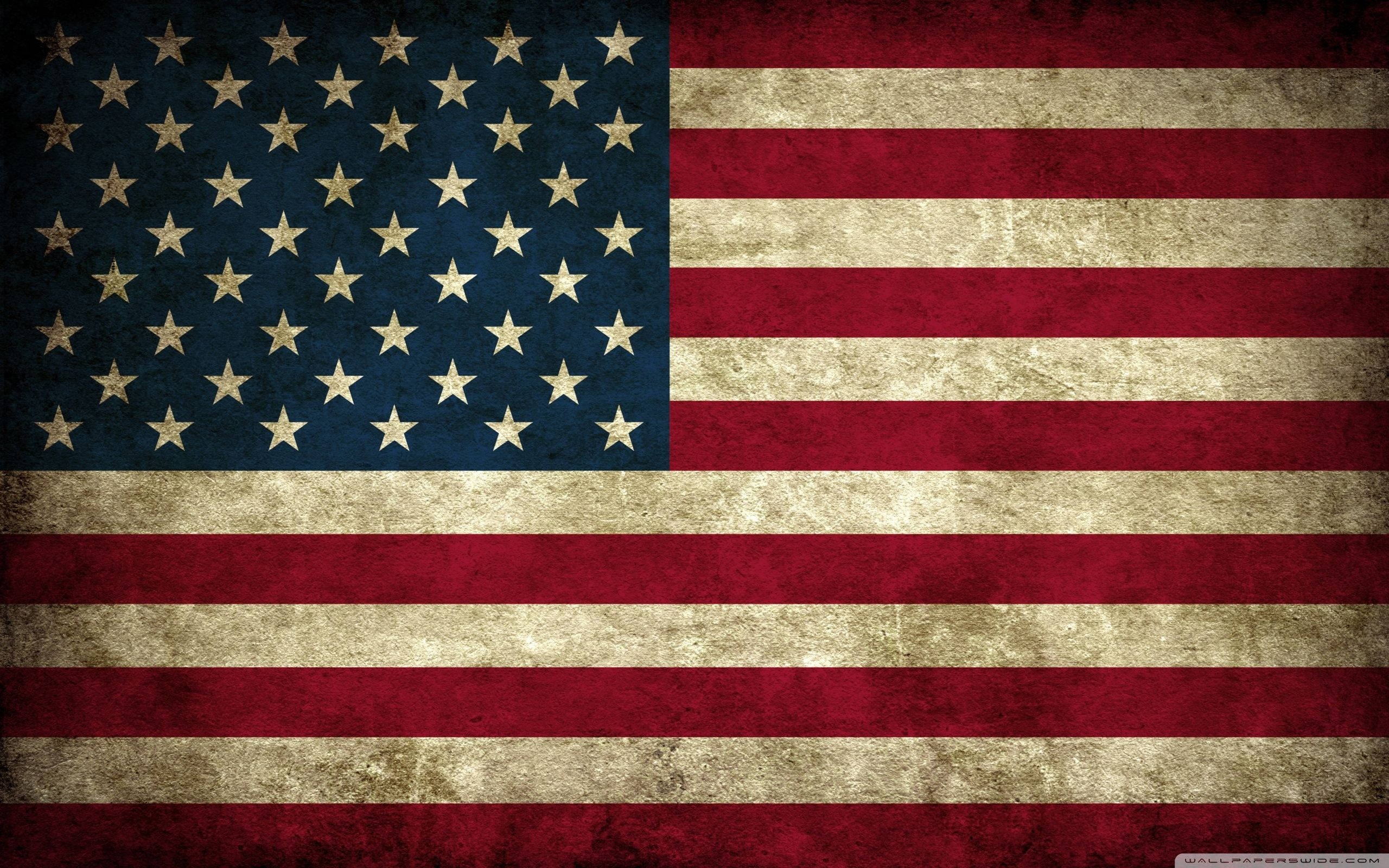USA 桌布 壁紙 — 一面經風化的美國國旗，帶有褪色的紅白條紋和藍色底上的金色星星，顯示出歲月和使用痕跡。