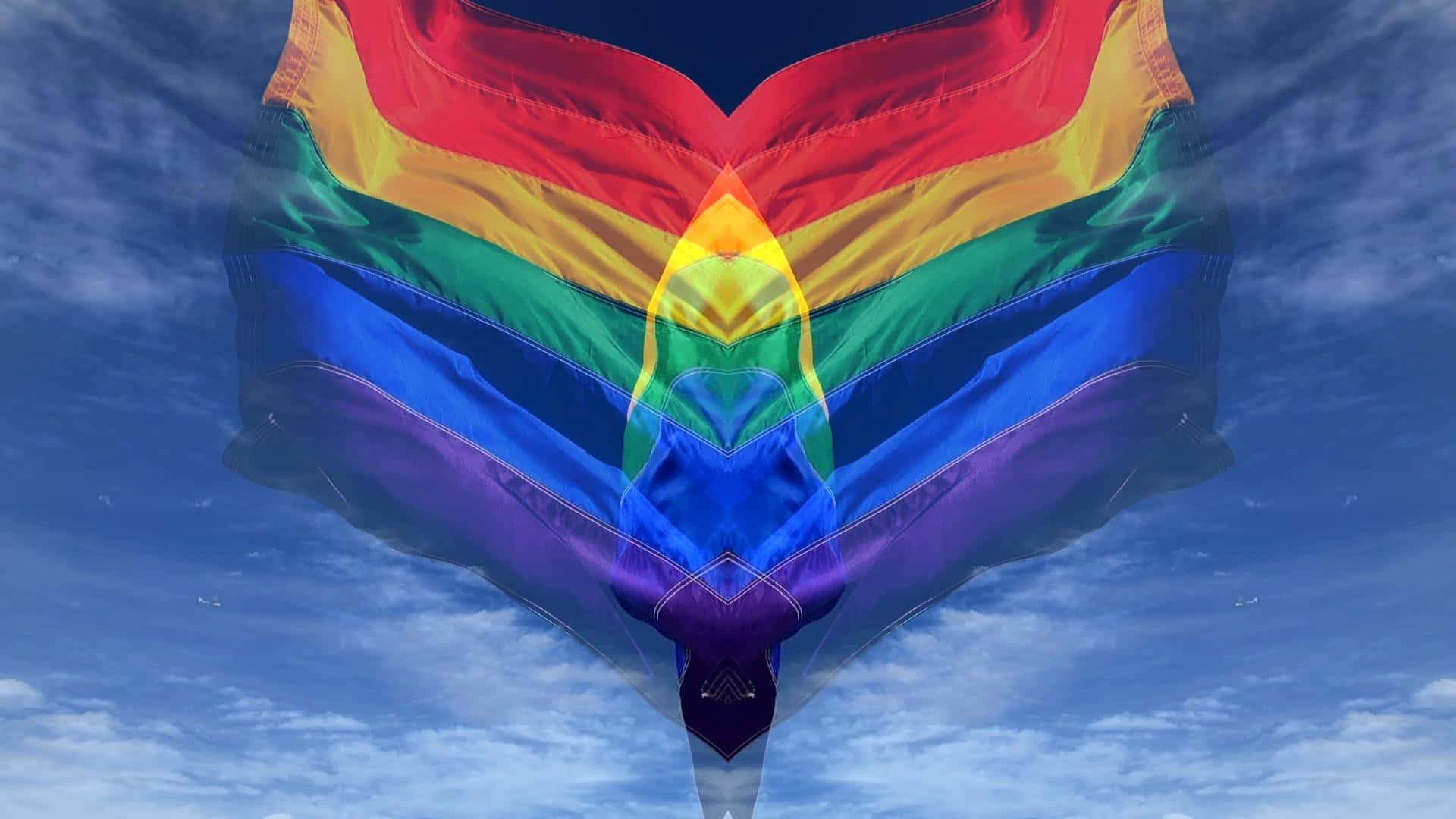 LGBT 桌布 壁紙 — 一面色彩繽紛的彩虹心形旗幟在藍天白雲中飄揚。