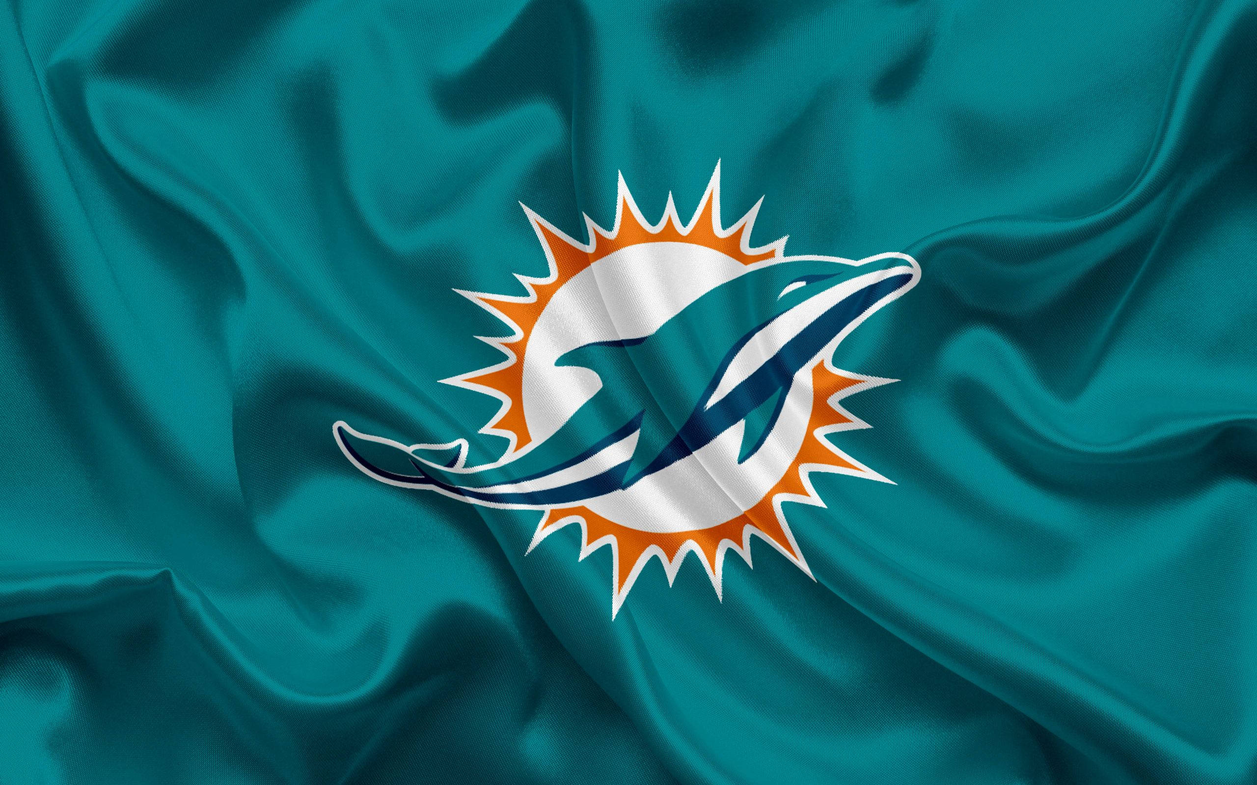 dolphins 桌布 壁紙 — 一面青綠色緞面旗幟，表面有白色、橙色和青綠色波浪中跳躍的海豚標誌。