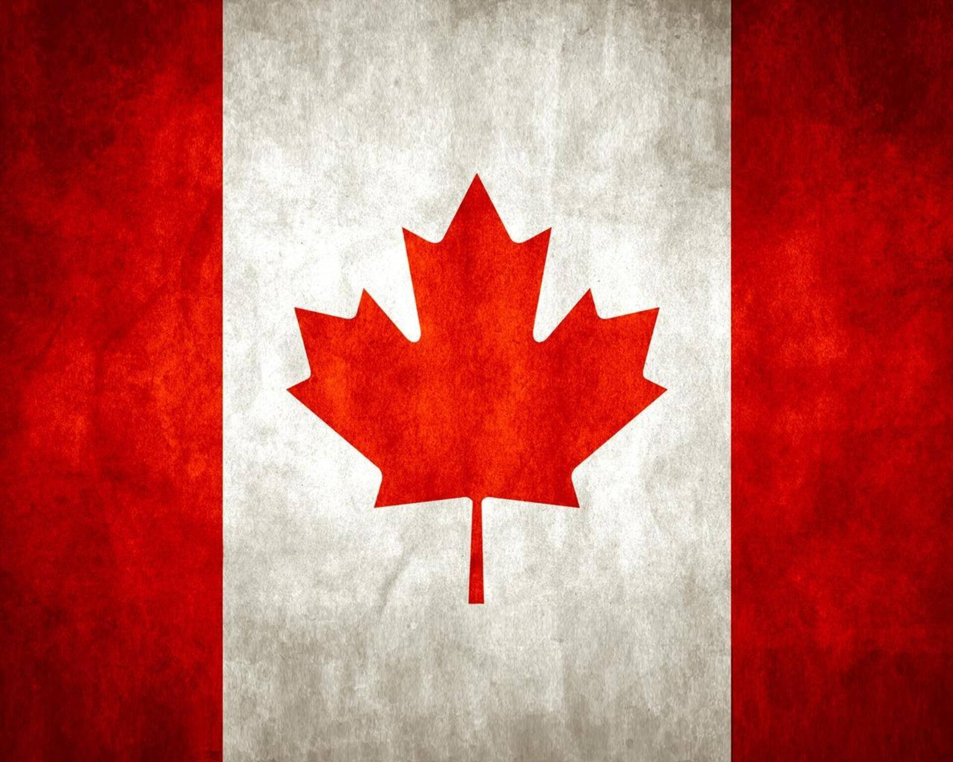 Canada Day 桌布 壁紙 — 一面風化的加拿大國旗，中央有鮮明的紅色楓葉，位於有紋理的白色條紋上，兩側是紅色垂直條紋。