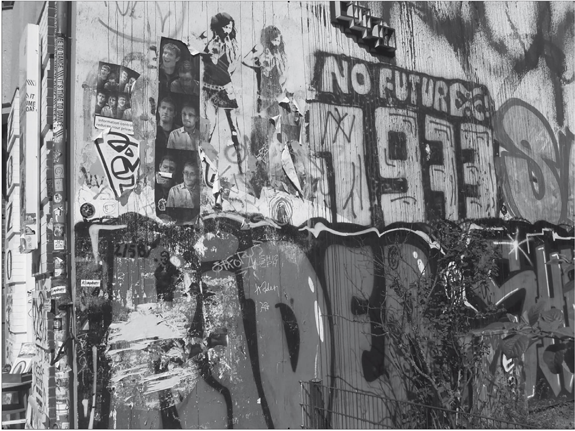 Black And White Graffiti 桌布 壁紙 — 一面風化的城市牆壁，覆蓋著層層疊疊的塗鴉貼紙、海報和噴漆，粗體文字寫著 no futures 1973。