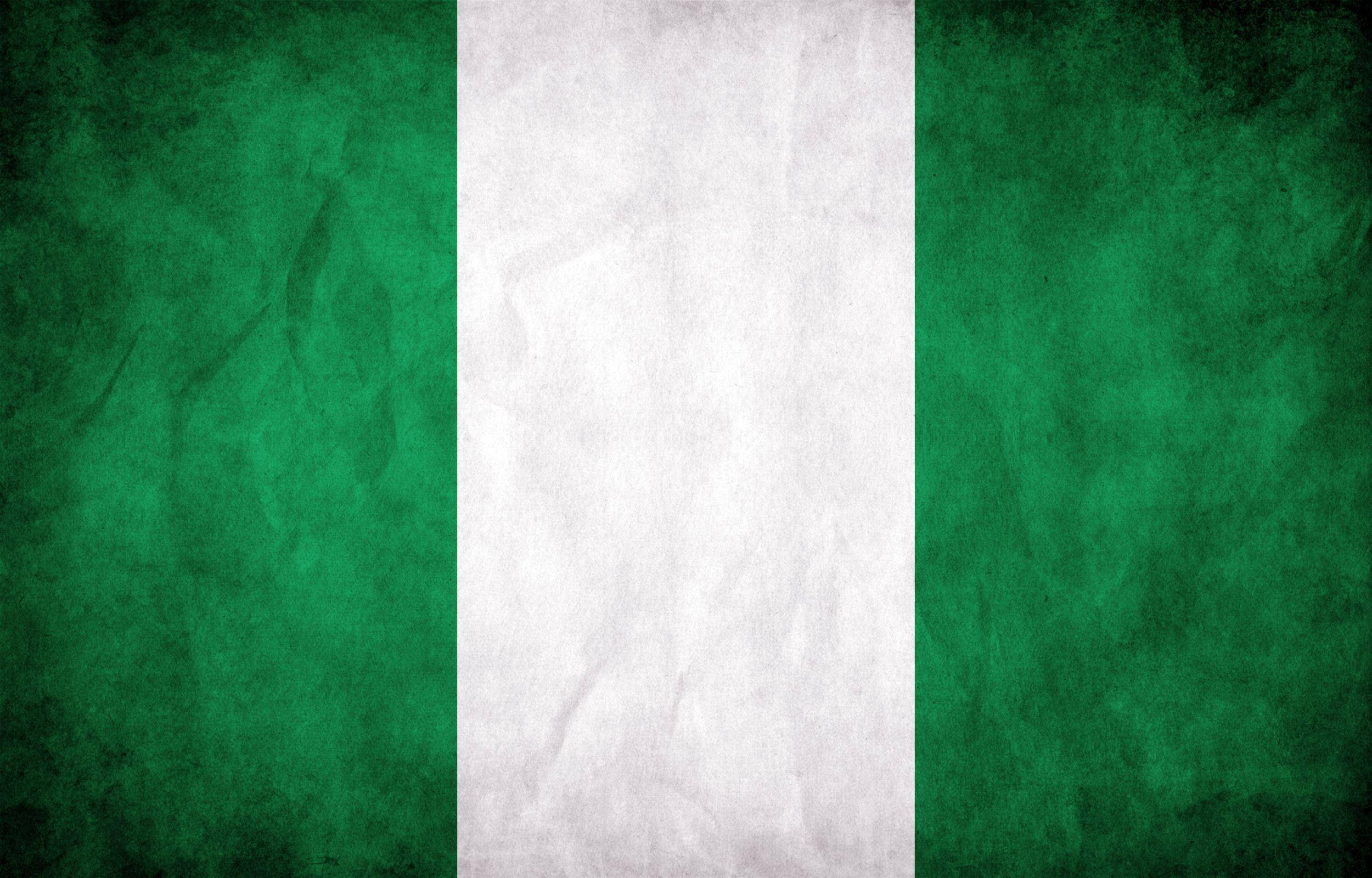 Nigeria 桌布 壁紙 — 一面風化的奈及利亞國旗，帶有綠色、白色、綠色的垂直條紋，顯示摺痕和質感。