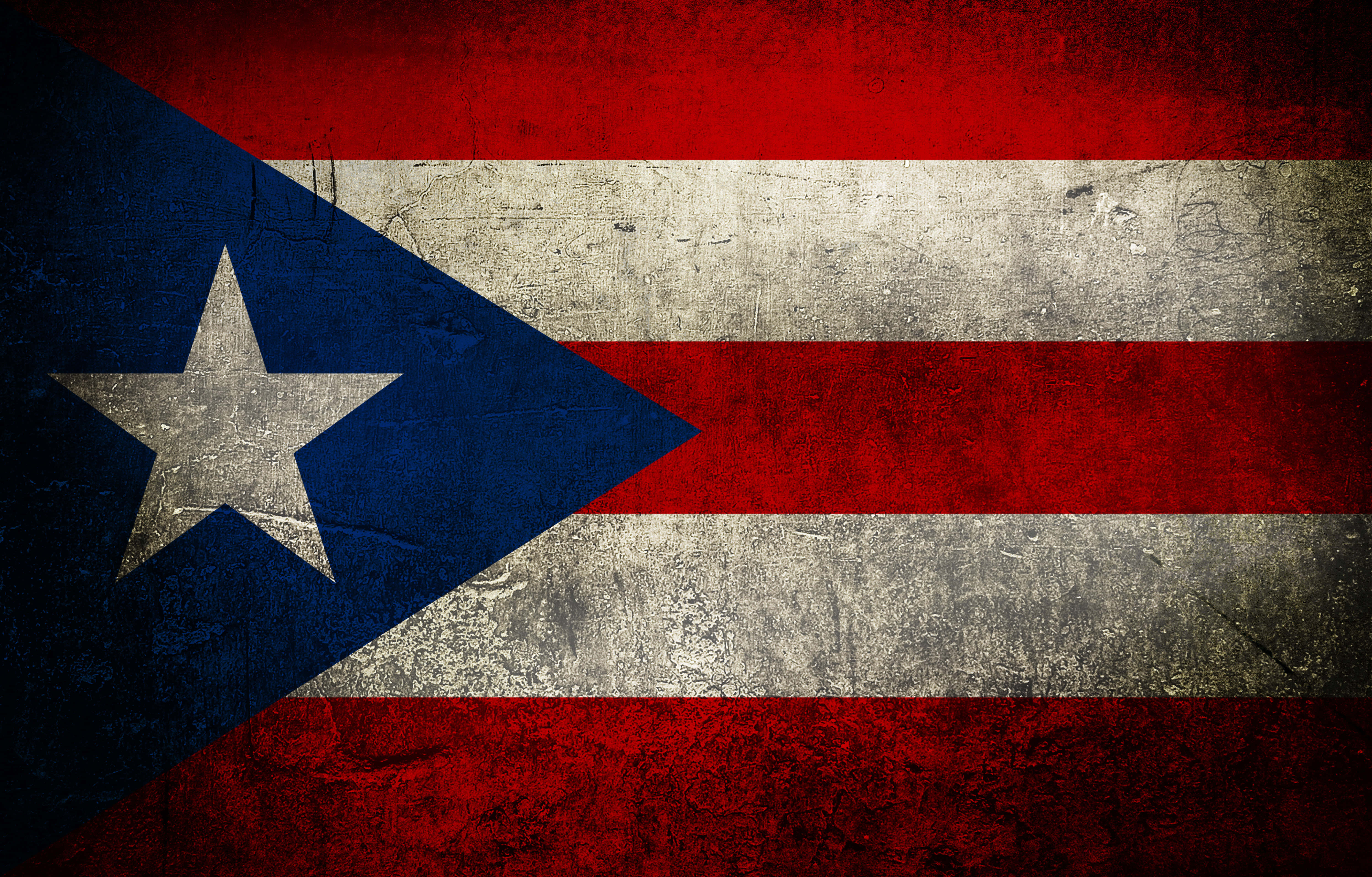 Puerto Rican 桌布 壁紙 — 一面風化的波多黎各旗幟，帶有紅色、白色和藍色條紋及一顆星星，顯示出可見的刮痕和紋理。