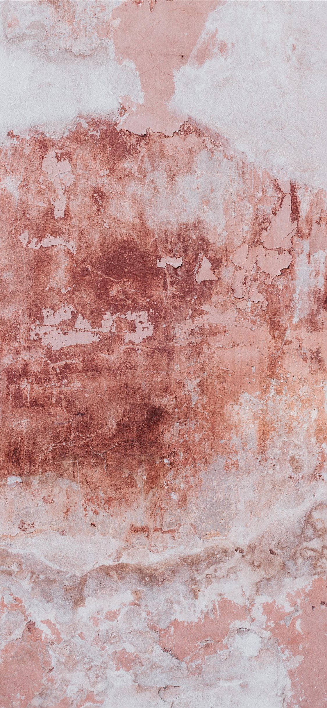 Beige iPhone 桌布 壁紙 — 一面風化的牆壁，粉紅色和白色的油漆剝落，露出下面的紋理層。
