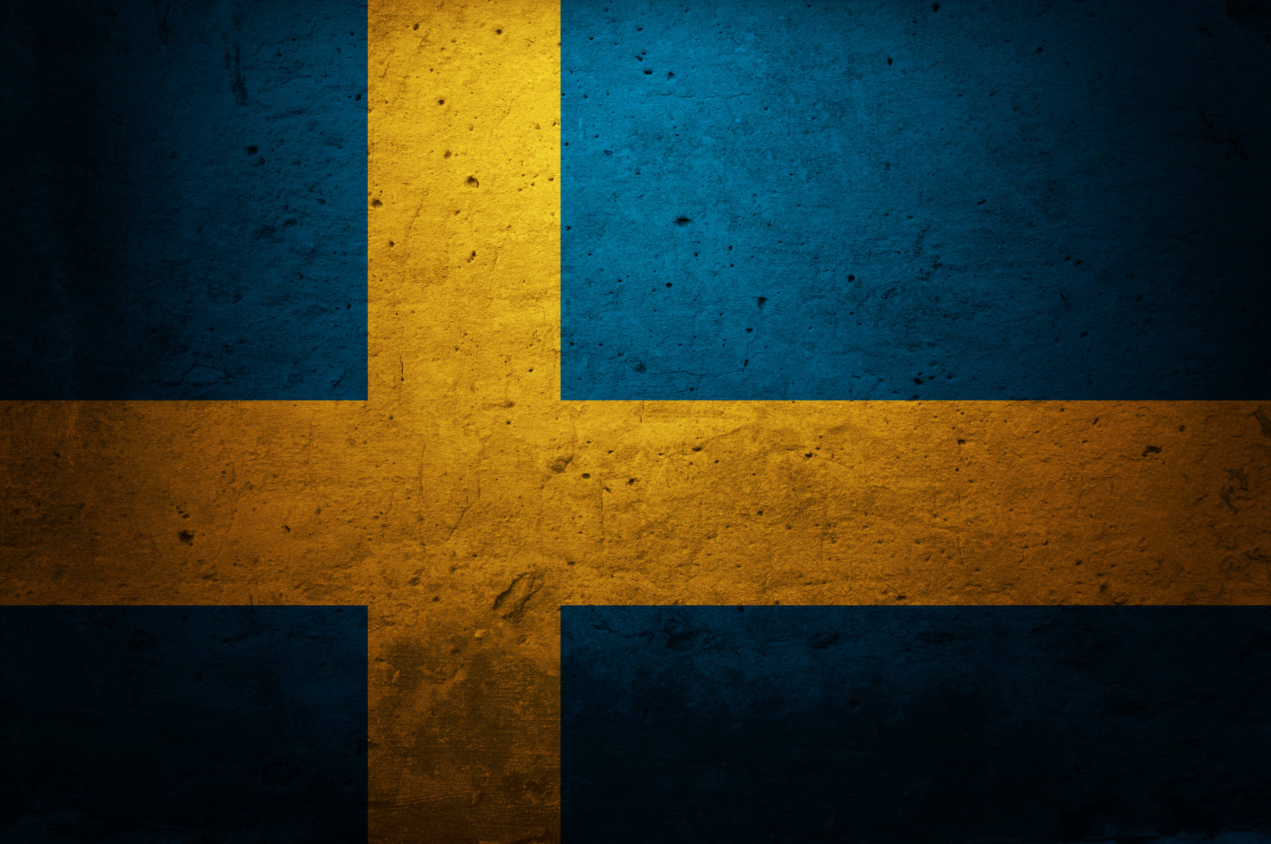 Sweden 桌布 壁紙 — 一面風化的瑞典國旗，藍色和黃色，顯示出粗糙的紋理表面，帶有可見的刮痕和污漬。