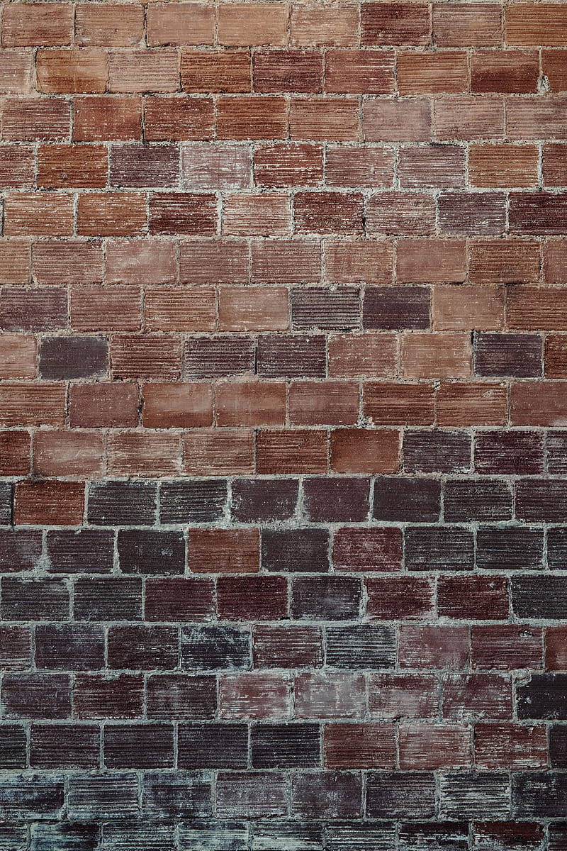 Brick Wall 桌布 壁紙 — 一面風化的磚牆，帶有各種大地色調和紋理灰泥線，顯示出歲月和曝露的痕跡。
