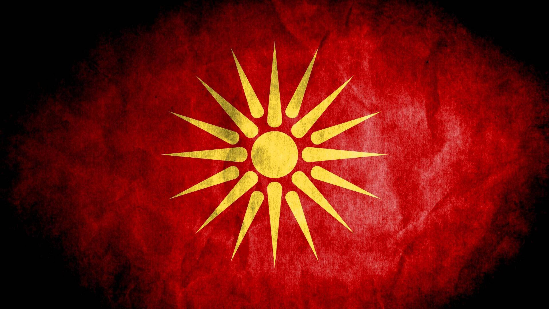 Flag 桌布 壁紙 — 一面風化的紅旗，帶有金色太陽標誌，在深色紋理背景上散發光芒。