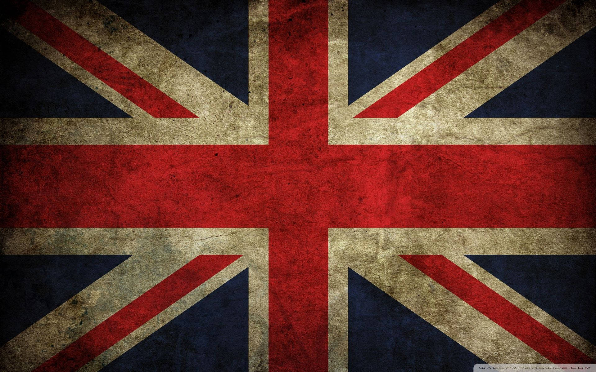 United Kingdom Flag 桌布 壁紙 — 一面風化的英國國旗，帶有褪色的紅、白、藍色，顯示出可見的紋理和污垢。