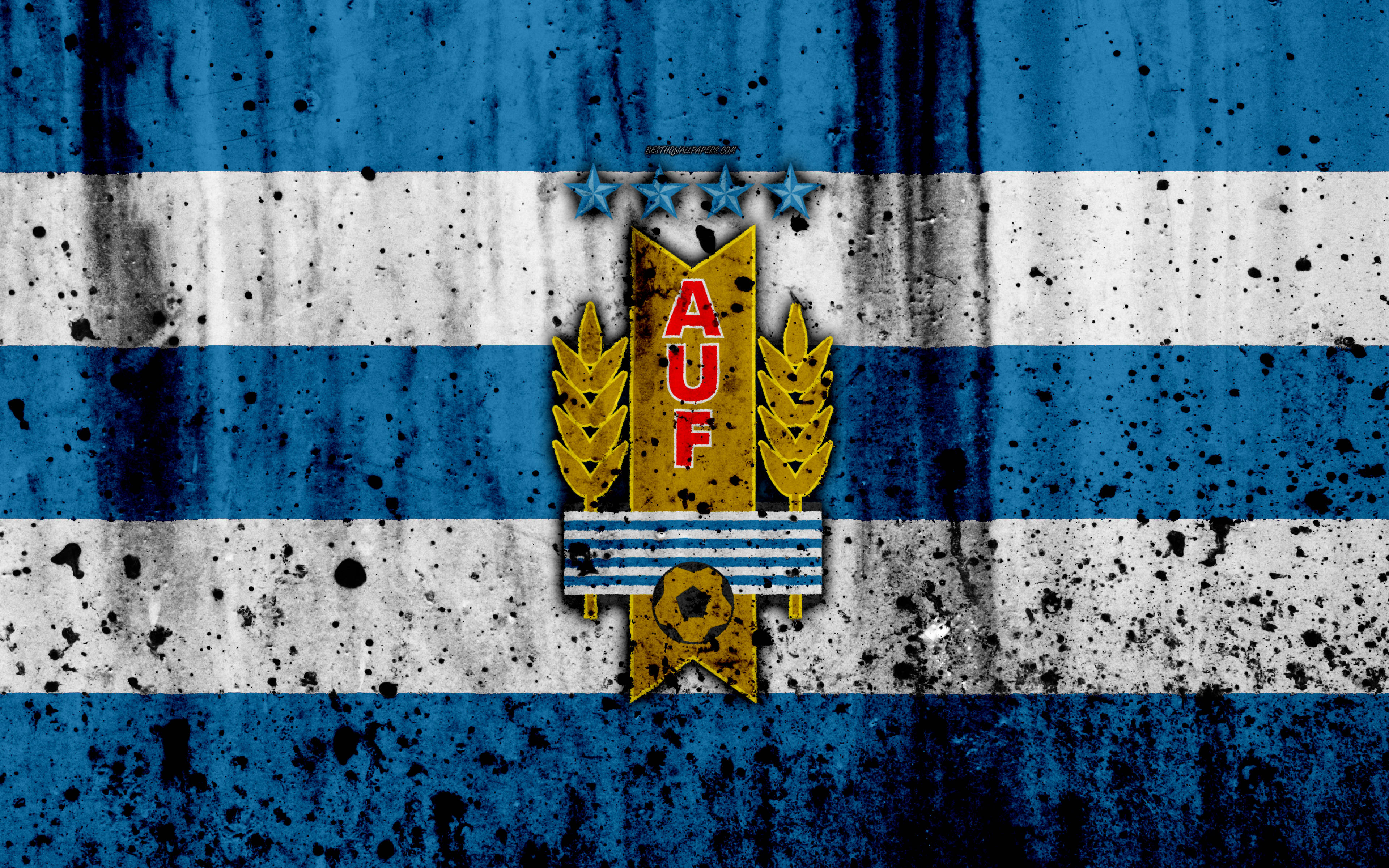 Uruguay 桌布 壁紙 — 一面風化的藍白條紋旗幟，中央有金色徽章，上面有AUF文字、麥穗和足球。