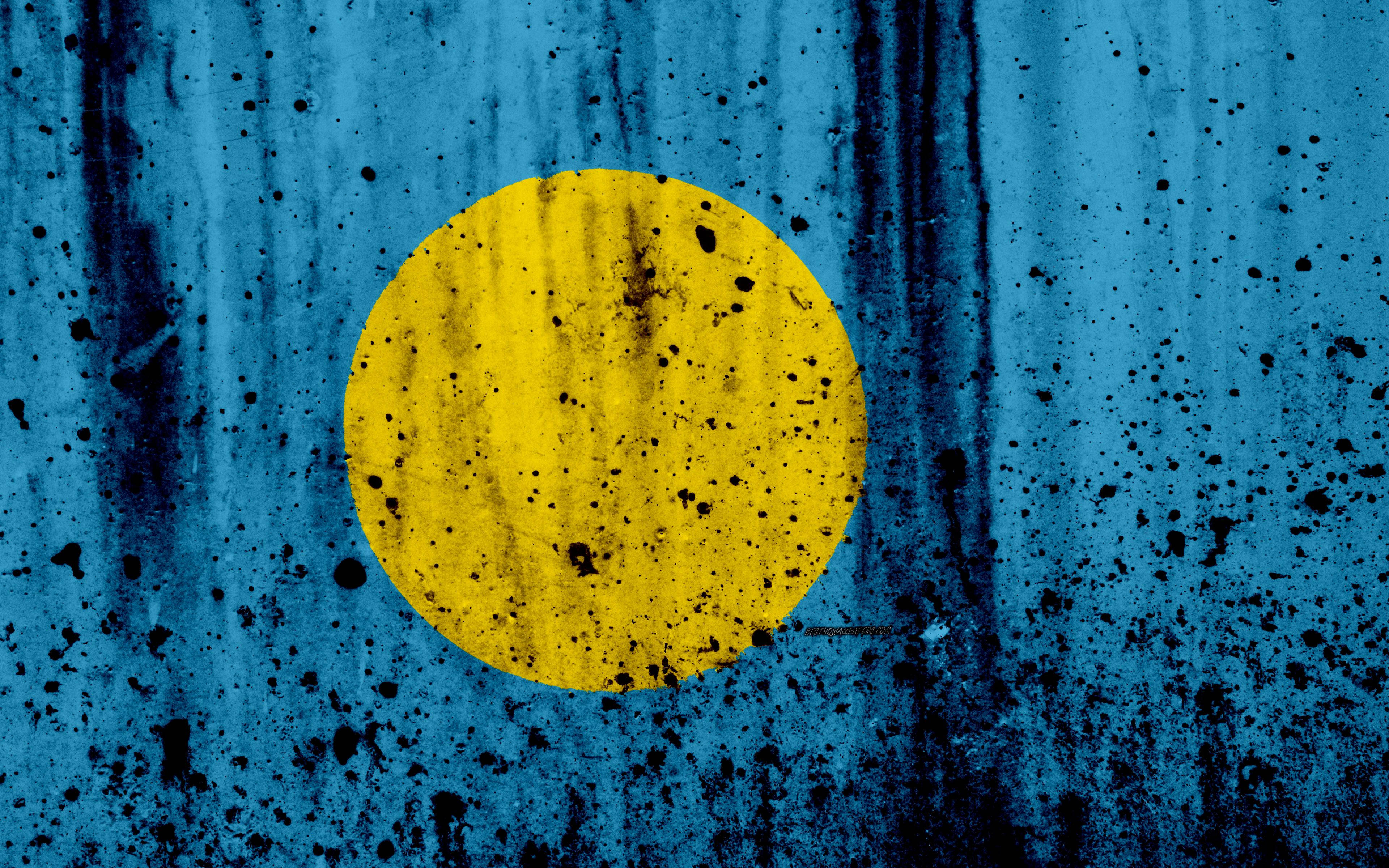 Palau 桌布 壁紙 — 一面風化的藍色旗幟，中央有一個黃色圓圈，上面佈滿黑色飛濺和條紋。
