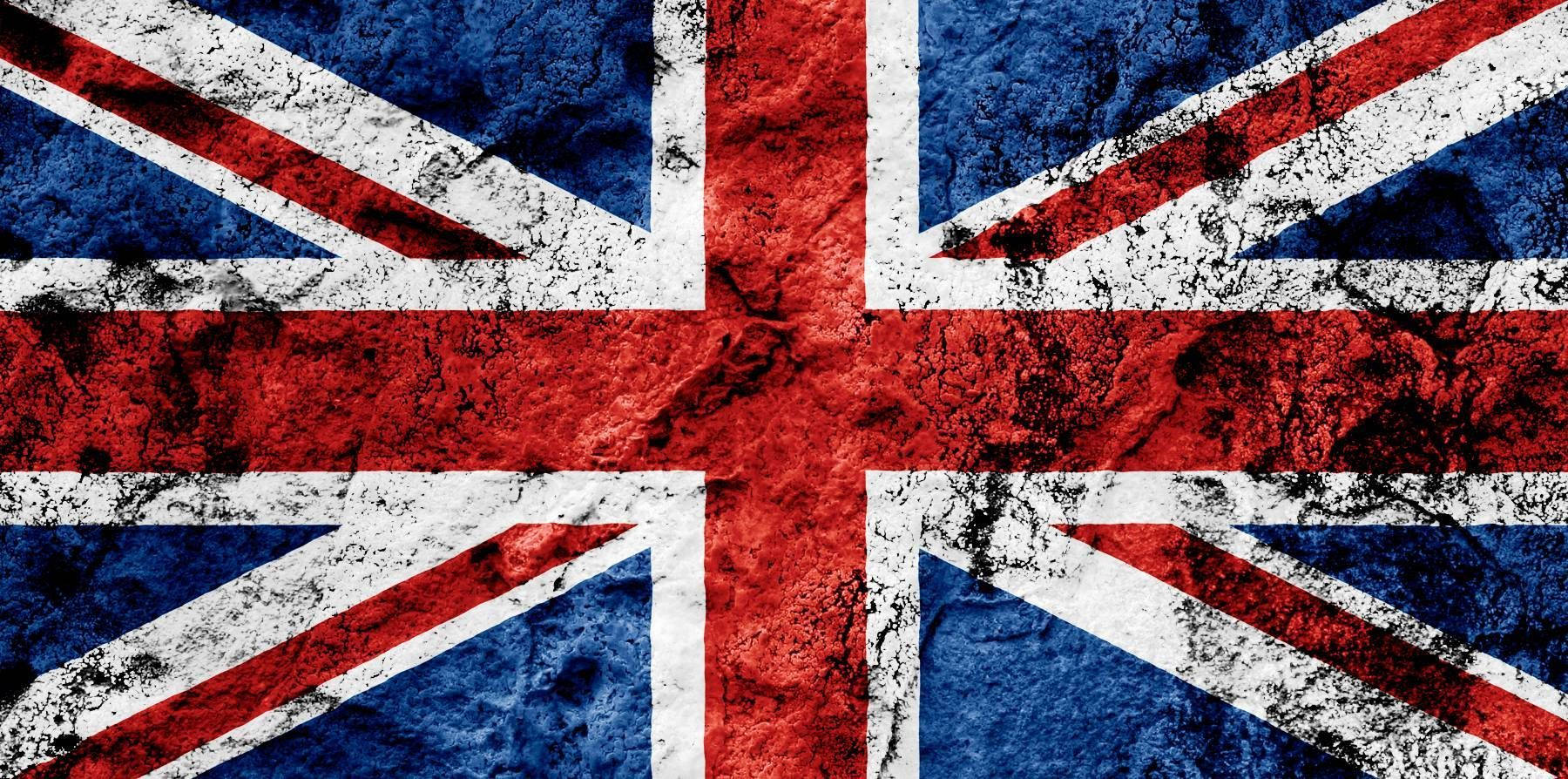 United Kingdom Flag 桌布 壁紙 — 一面風化紋理的英國國旗，帶有鮮明的紅、白、藍色，顯示磨損痕跡。