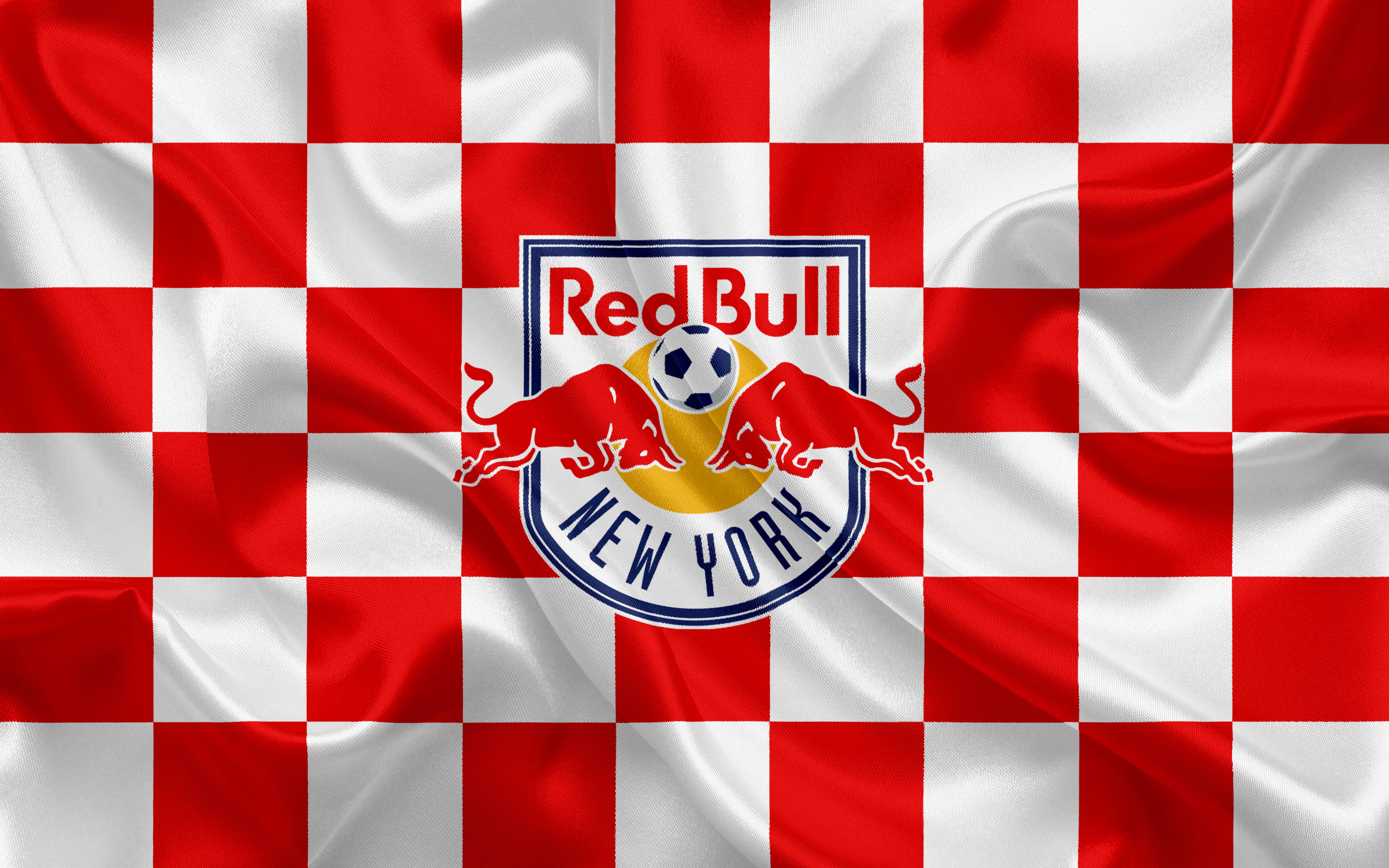 bull 桌布 壁紙 — 一面飄揚的紅白格子旗，上面有 Red Bull New York 足球隊標誌，兩頭紅牛夾著一個足球。