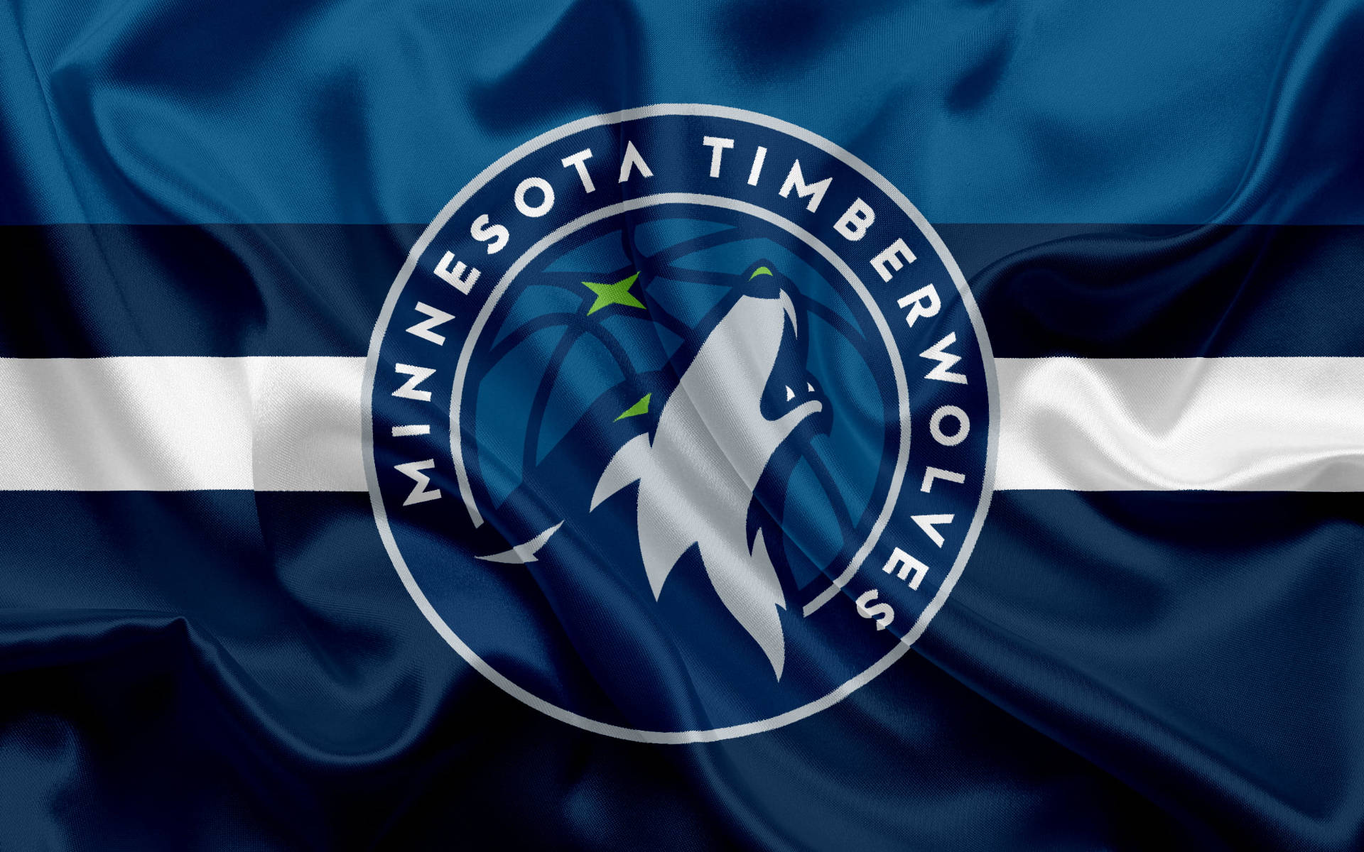 Timberwolves 桌布 壁紙 — 一面飄揚的藍白旗幟，上面有明尼蘇達灰狼隊的標誌，包含一隻嚎叫的狼和一個籃球。