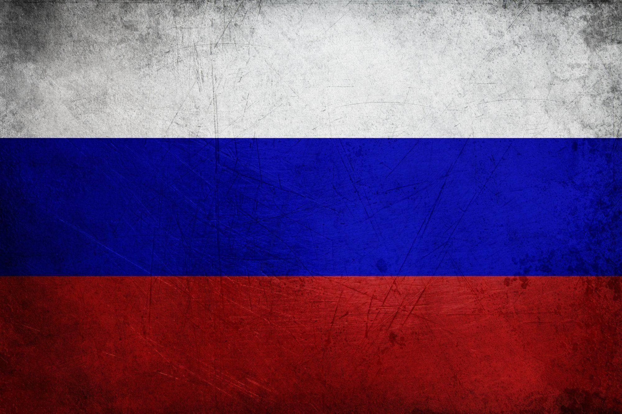 Russia 桌布 壁紙 — 一面飽經風霜的俄羅斯國旗，帶有醒目的白、藍、紅水平條紋，顯示出刮痕和污垢。