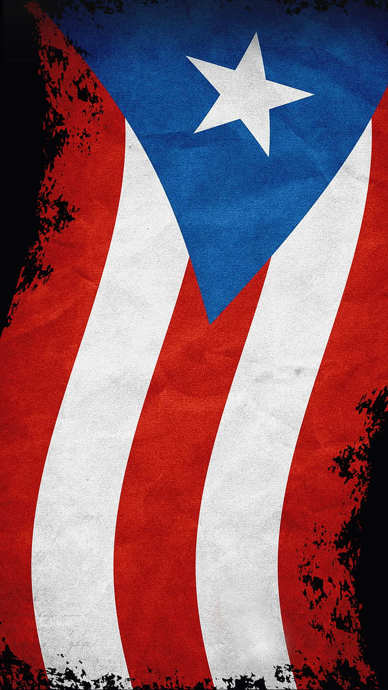 Puerto Rican 桌布 壁紙 — 一面飽經風霜的波多黎各旗幟，帶有鮮明的紅、白、藍條紋，以及藍色三角形上的白色星星，背景為深色紋理。