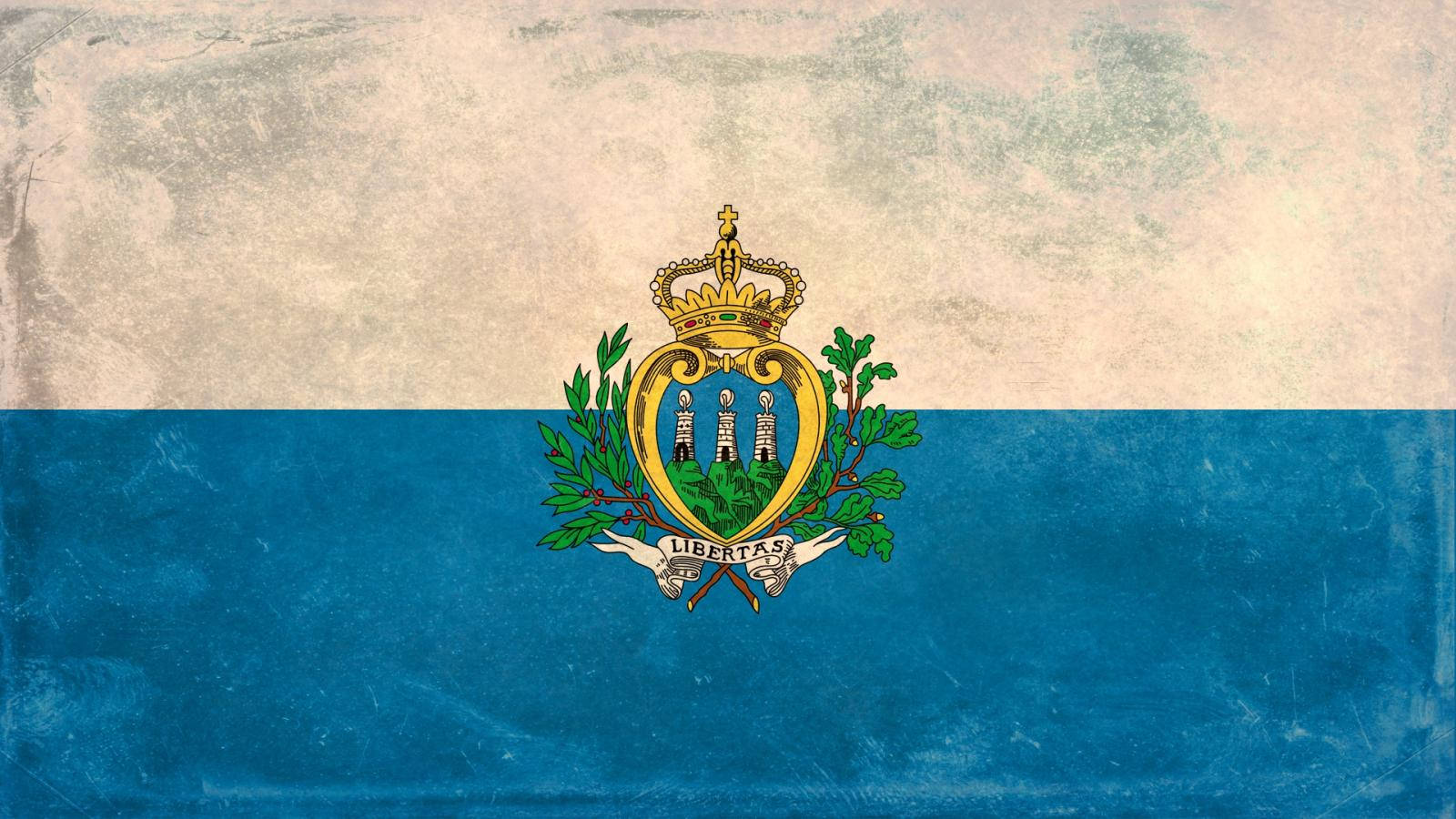 San Marino 桌布 壁紙 — 一面飽經風霜的聖馬利諾國旗，藍白條紋上有金色皇冠和盾牌。