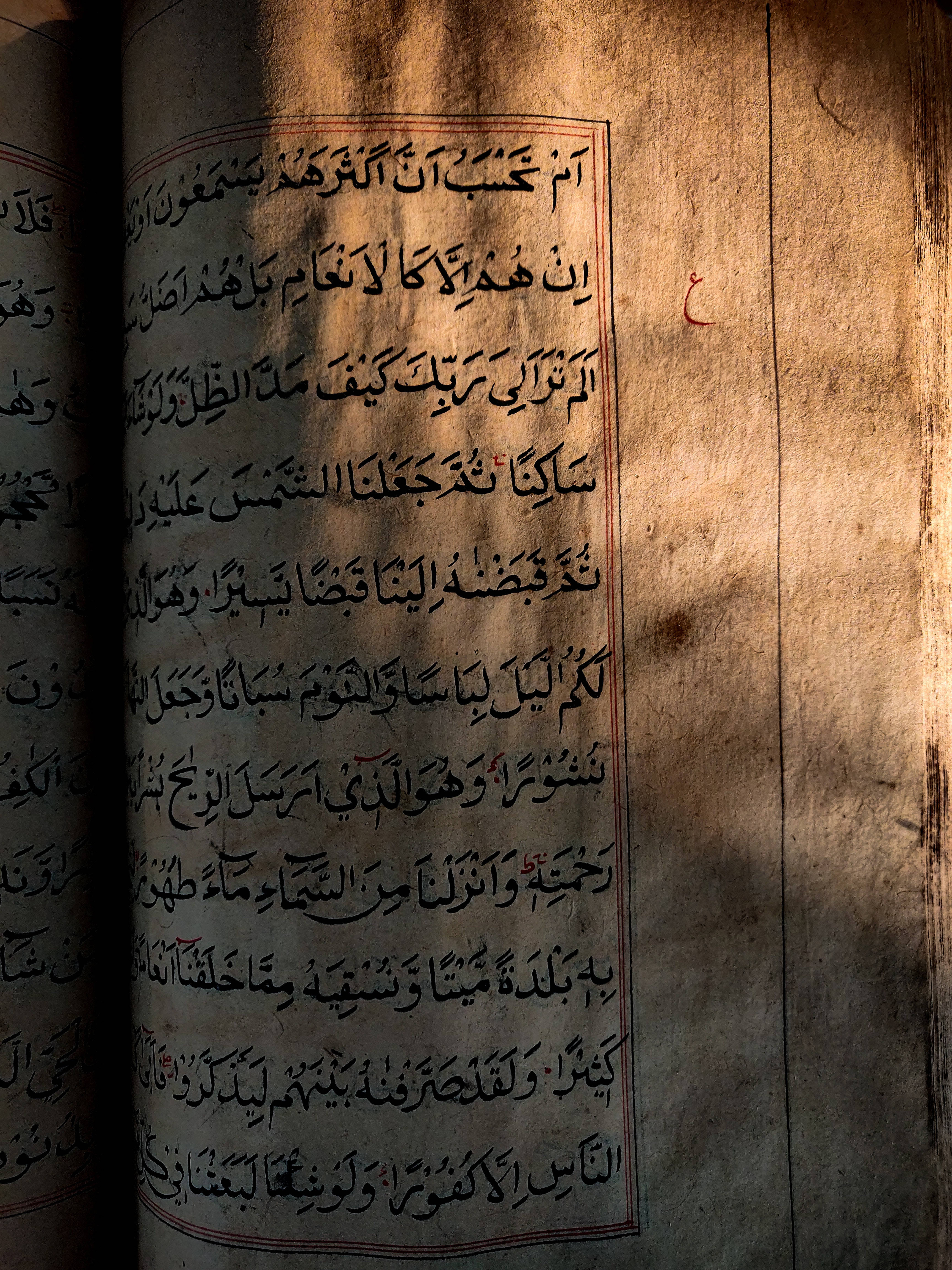 Best Islamic 桌布 壁紙 — 一頁古老手稿，上面有阿拉伯書法，被溫暖的陽光照射，在陳舊的羊皮紙上投下戲劇性的陰影。