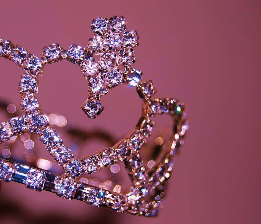 Princess Crown 桌布 壁紙 — 一頂鑲滿鑽石的閃亮頭冠，在柔和粉紅色背景與散景燈光下閃爍生輝。