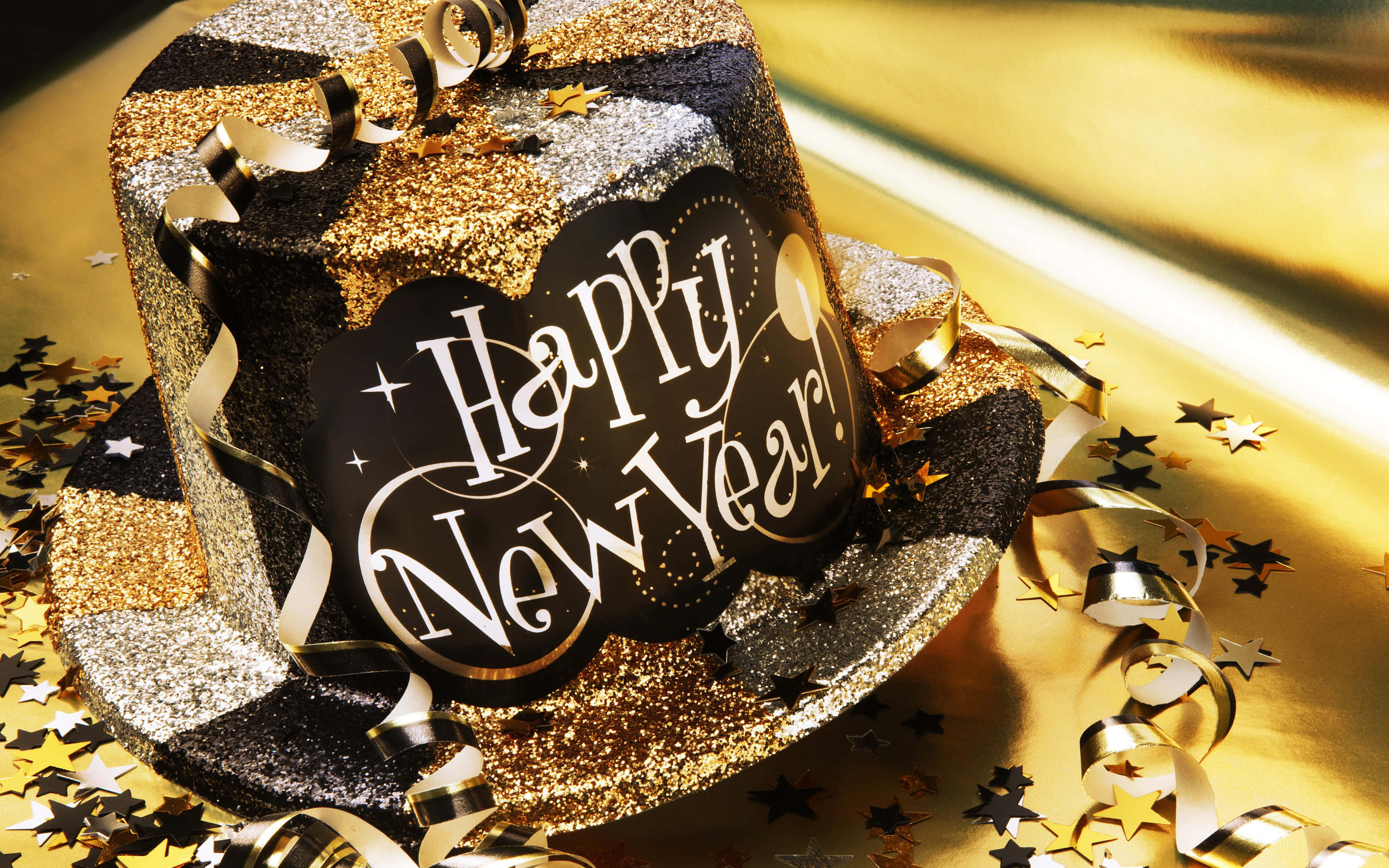 蛋糕 桌布 壁紙 — 一頂閃亮的黑色和金色高頂禮帽，帶有'Happy New Year!'標誌，周圍環繞著五彩紙屑和絲帶，置於金色表面上。