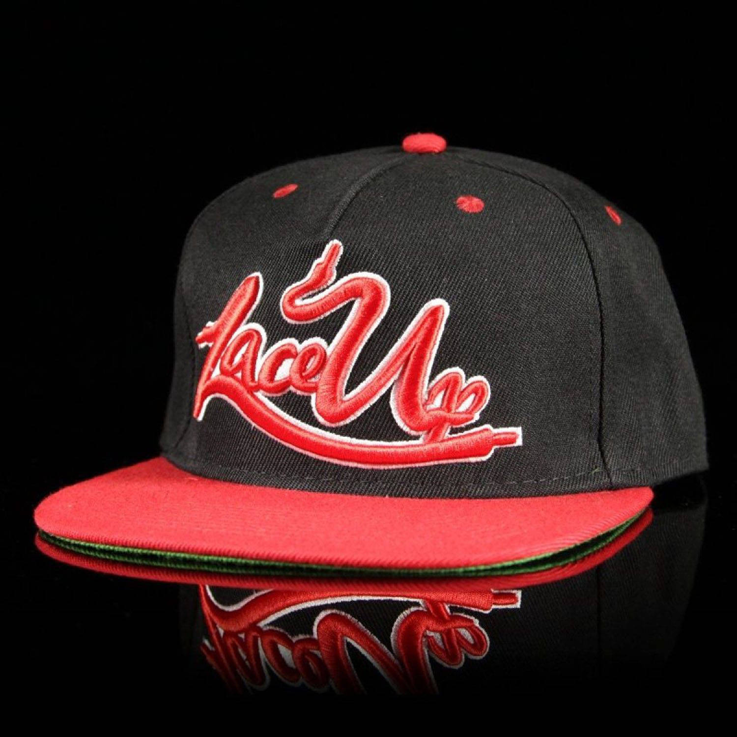 Lace 桌布 壁紙 — 一頂黑色 snapback 帽，帶有紅色 'Lace Up' 字體標誌和紅色帽檐，在光亮的黑色表面上清晰反射。