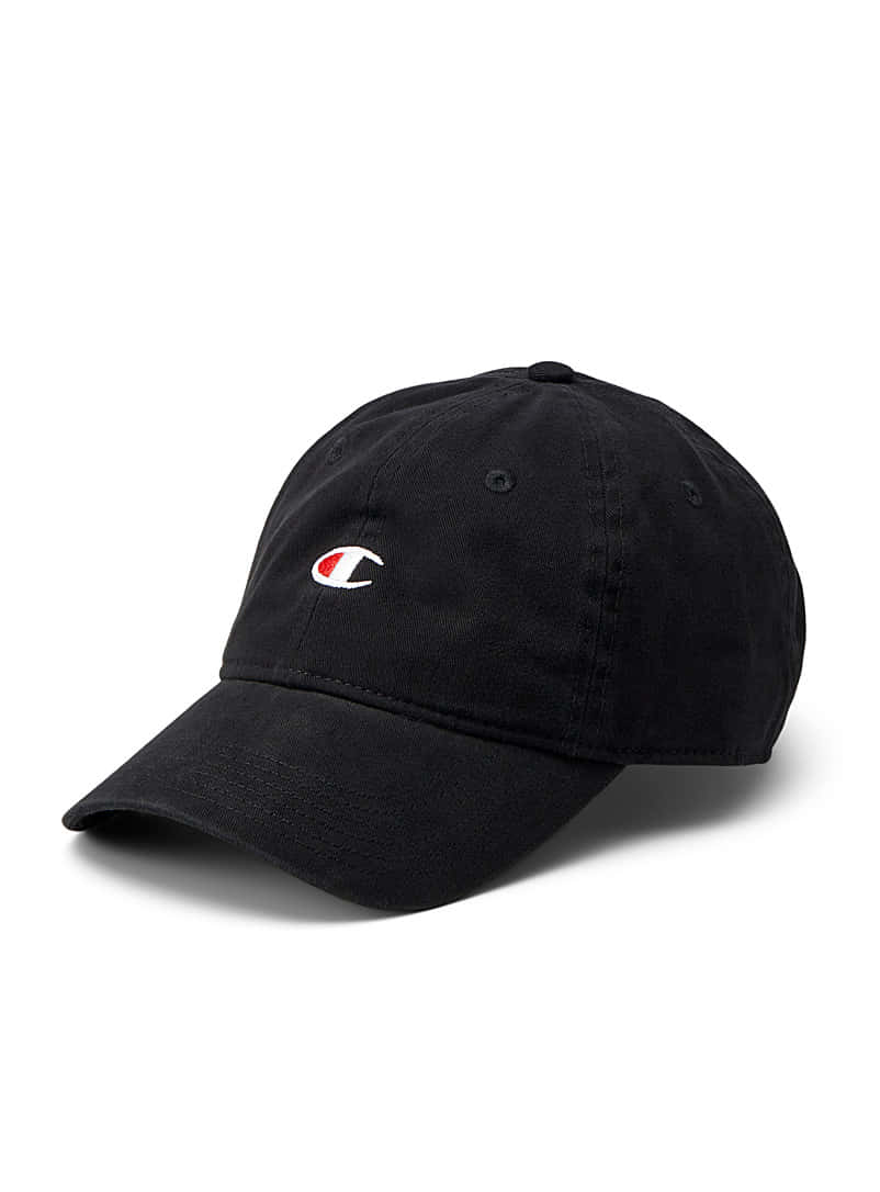 Champion 桌布 壁紙 — 一頂黑色Champion棒球帽，帶有紅色和白色標誌，斜放在純白色背景上。