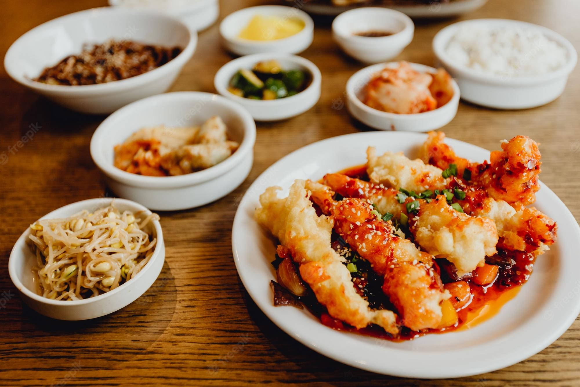 shrimp 桌布 壁紙 — 一頓充滿活力的韓國餐，包括酥脆的炸海鮮配辣醬，以及放在溫暖木桌上的配菜。