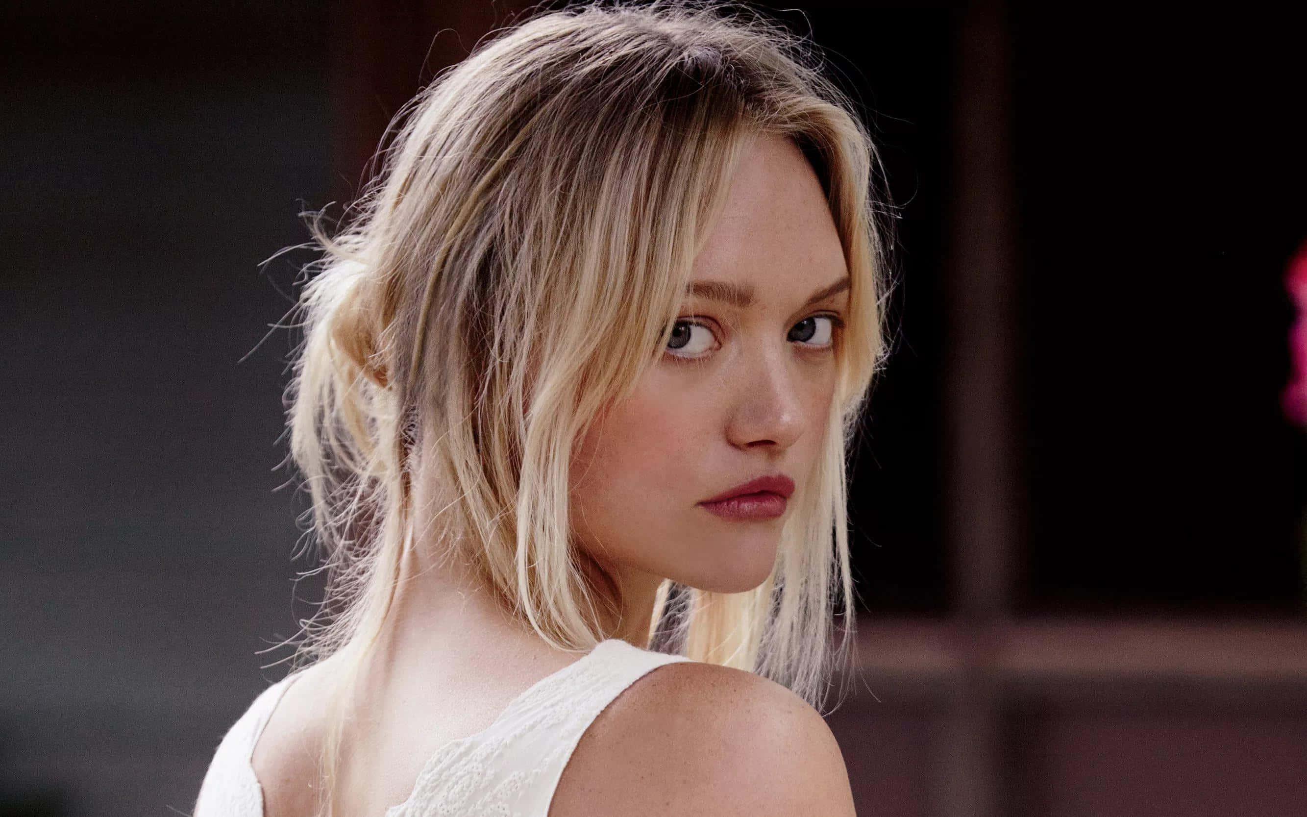 Gemma Ward 桌布 壁紙 — 一頭凌亂金髮的女子越過肩膀轉頭，直視鏡頭，表情嚴肅。