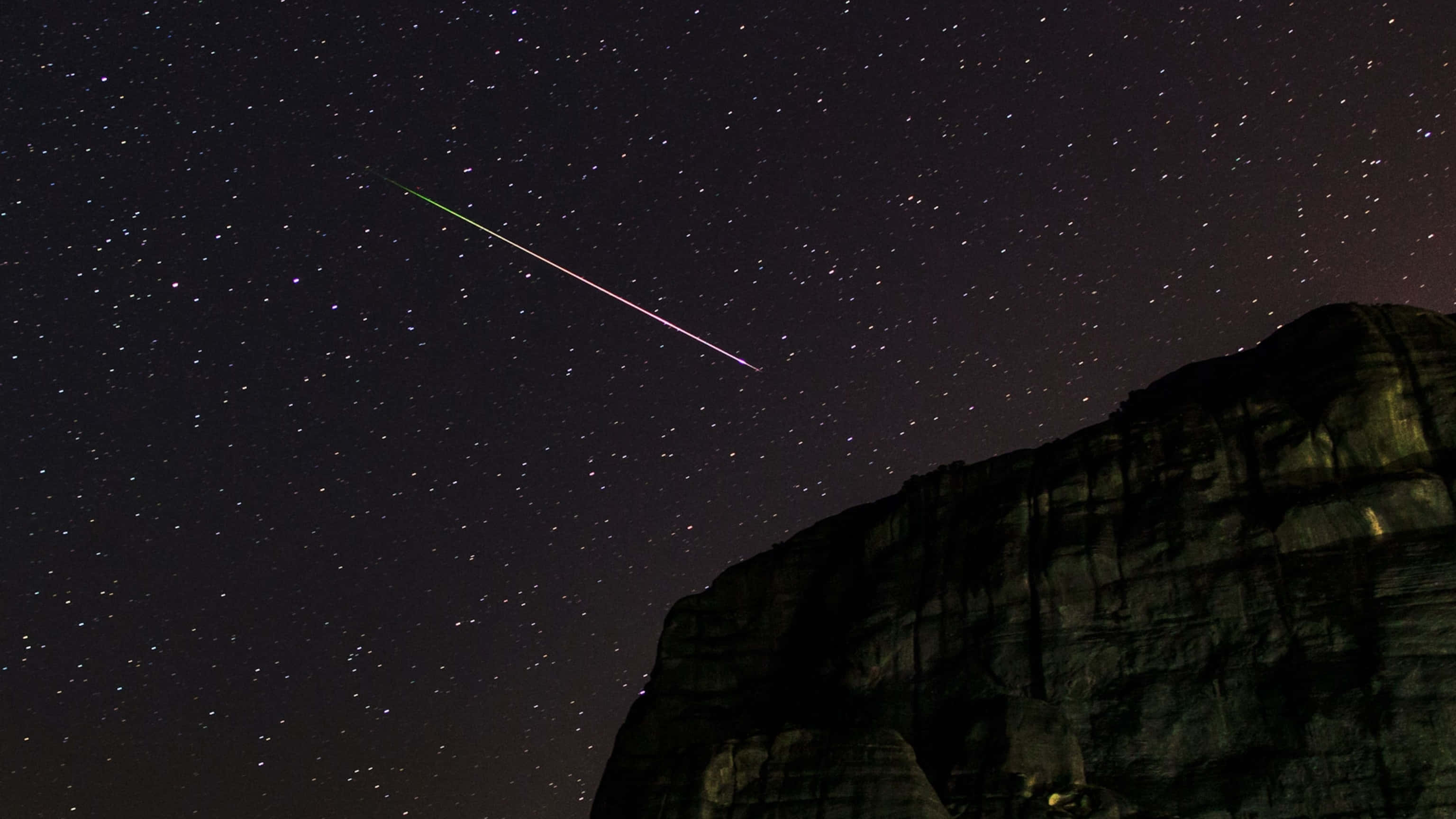 meteor 桌布 壁紙 — 一顆充滿活力的流星劃過崎嶇懸崖上方的星空夜空。