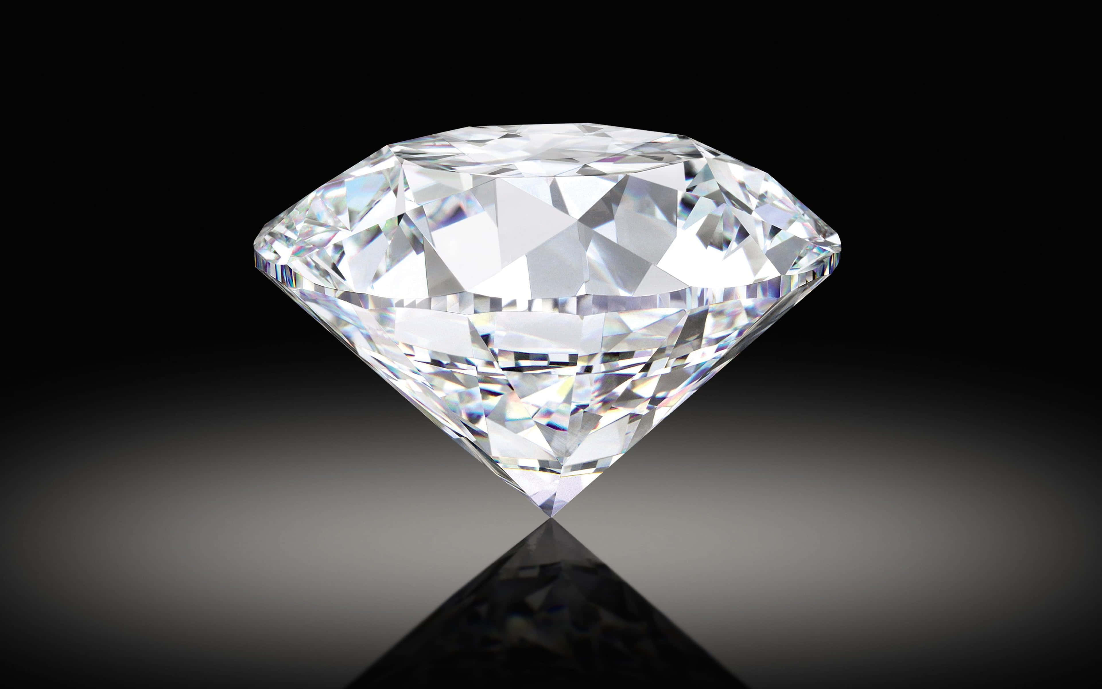 Gemstone 桌布 壁紙 — 一顆完美無瑕的鑽石在純黑背景下閃耀著銳利的切面，在光滑表面上投射出清晰的倒影。