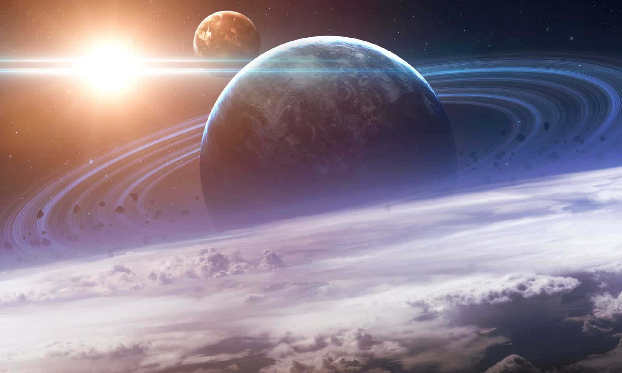 土星 桌布 壁紙 — 一顆宏偉的環狀行星在燦爛的太陽下發光，下方有遙遠的月球和旋轉的雲層。