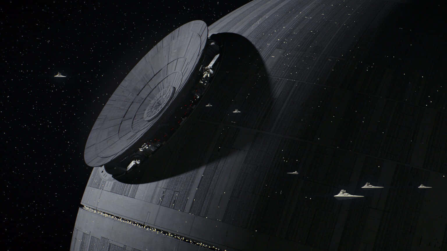 The Trench Run 桌布 壁紙 — 一顆巨大的灰色死星懸浮在太空中，星際戰鬥機在其表面周圍飛翔，背景是繁星點點。