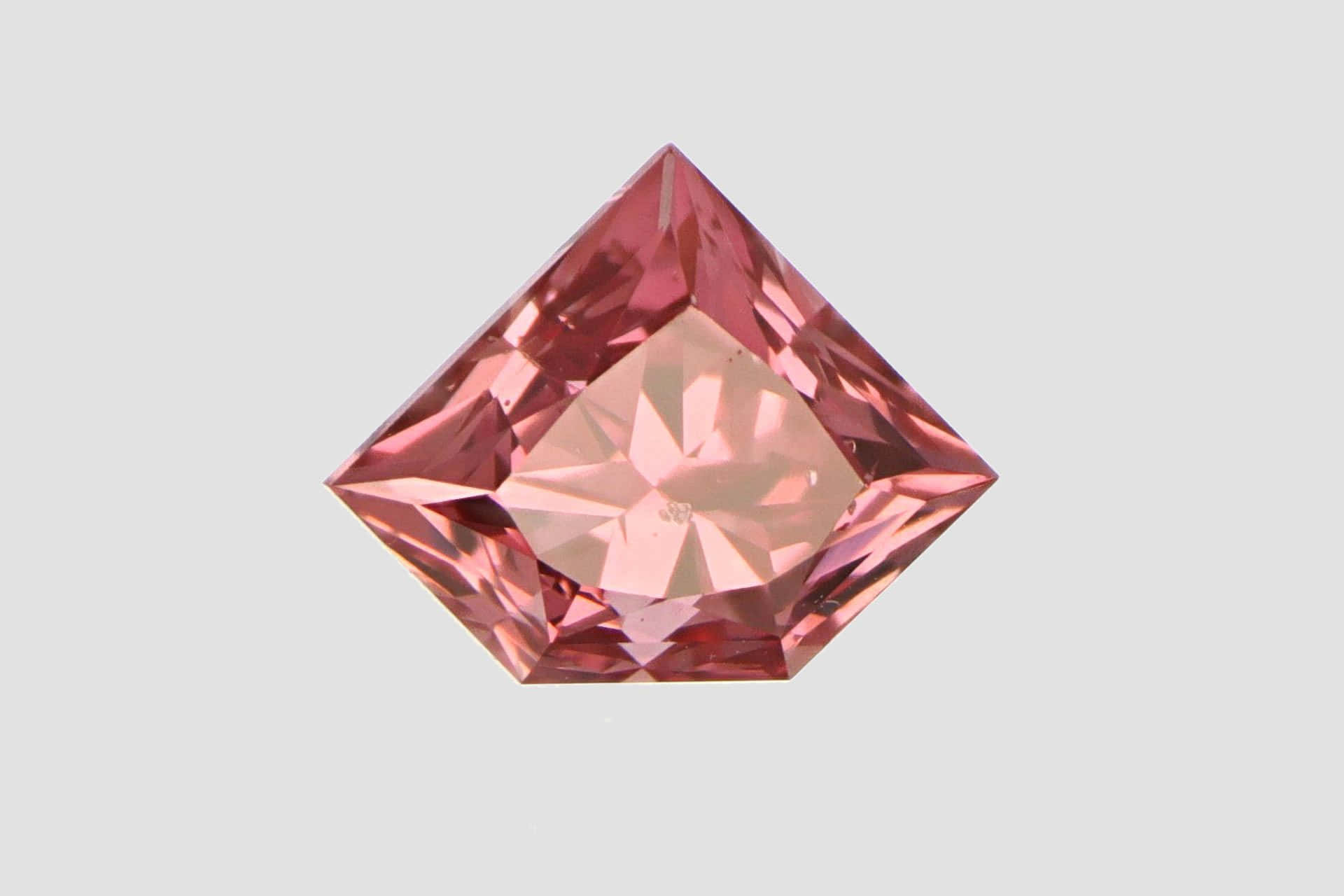 Pink Diamond 桌布 壁紙 — 一顆帶有精確切割面的閃亮粉紅色鑽石，在柔和的灰色背景上閃耀。