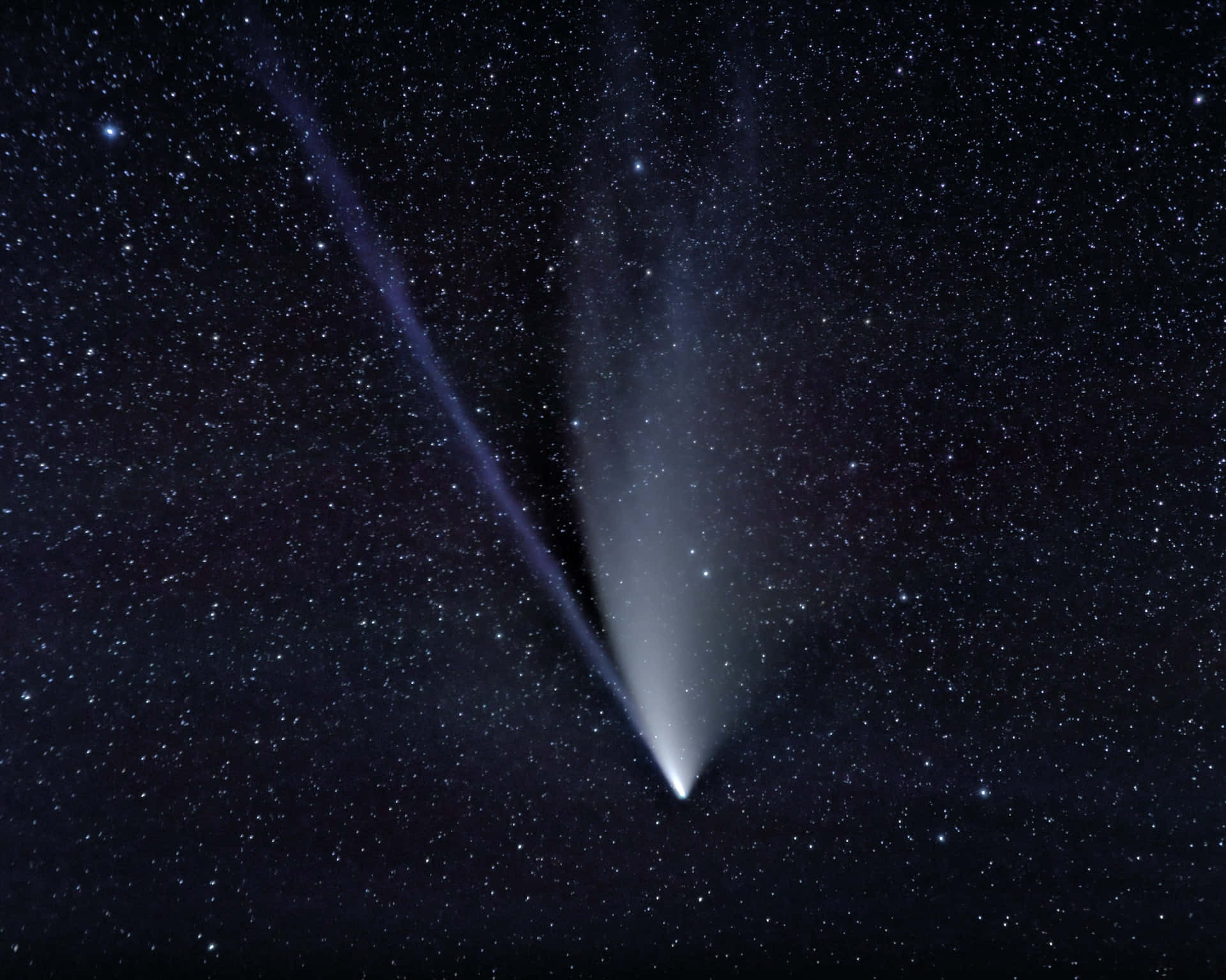 comet 桌布 壁紙 — 一顆明亮的彗星劃過繁星點點的夜空，帶有明亮的彗核和兩條發光的彗尾。
