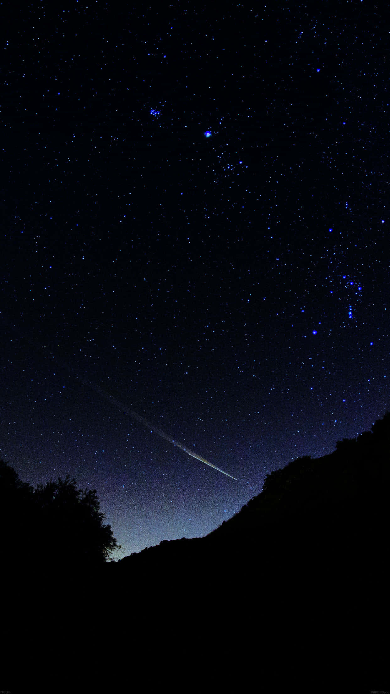 Dark Sky 桌布 壁紙 — 一顆明亮的流星劃過繁星點點的夜空，下方是黑暗的山丘和樹木剪影。