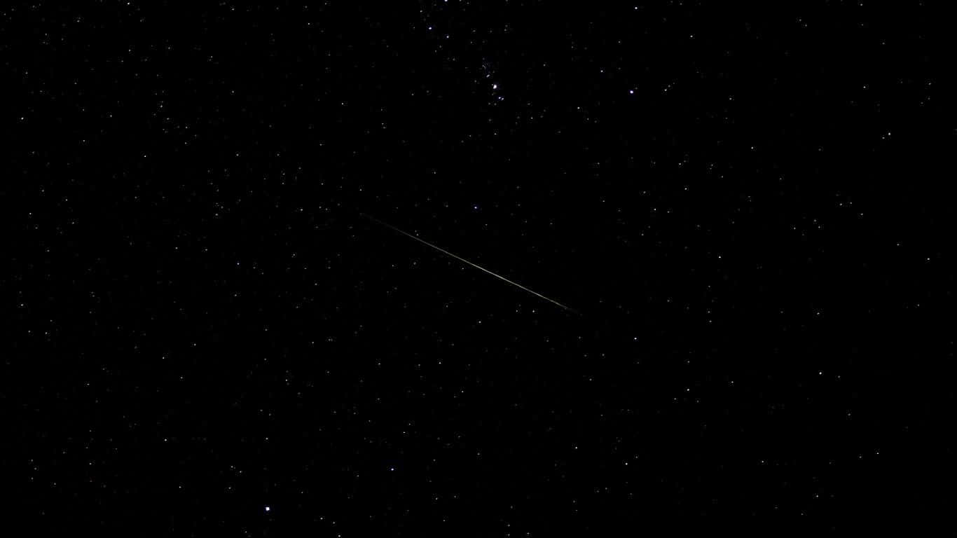 桌布 壁紙 — 一顆明亮的流星對角劃過佈滿星星的黑色夜空。
