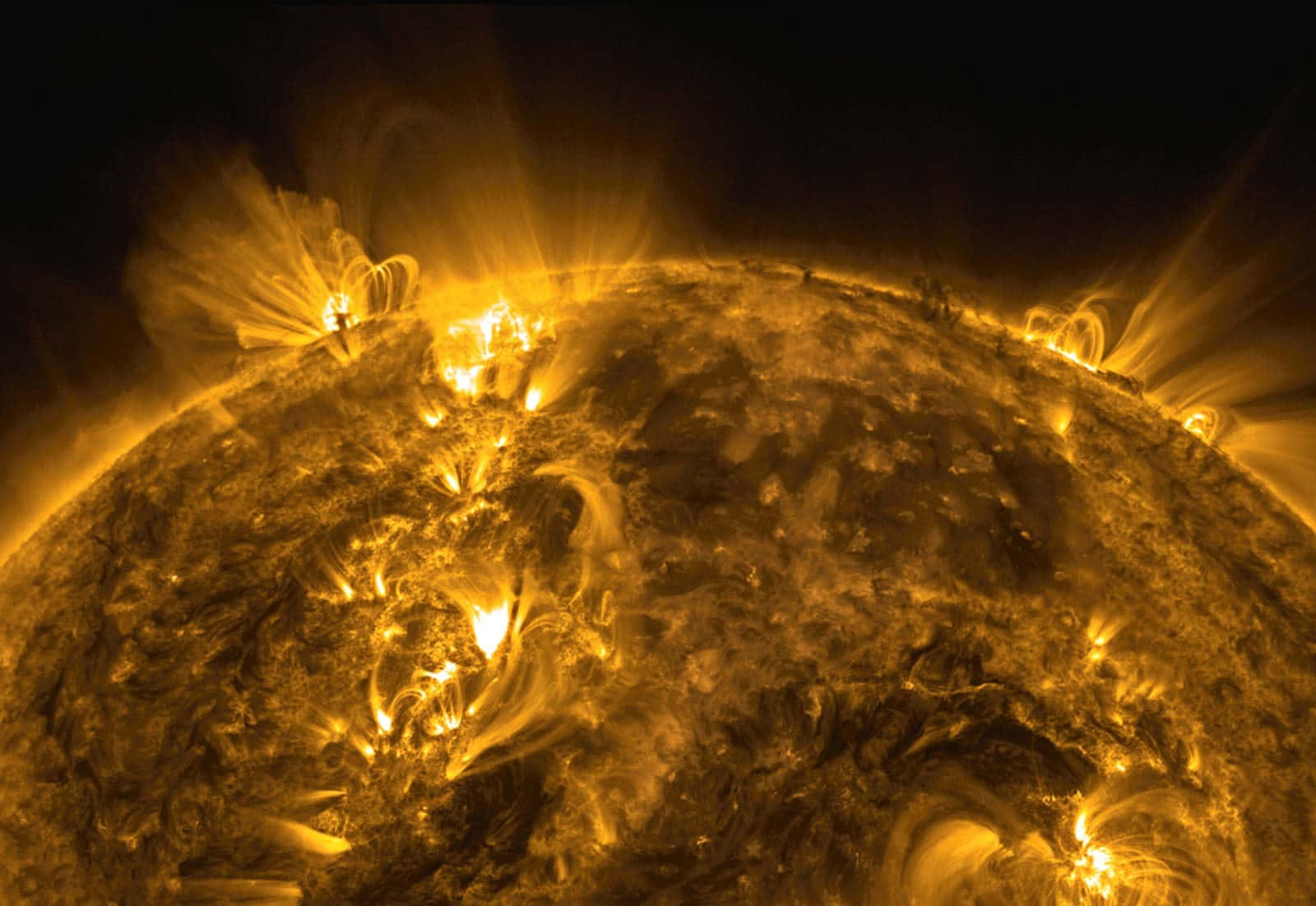 太陽 桌布 壁紙 — 一顆熾熱的太陽，其動盪的表面噴發出熾熱的太陽耀斑，映襯著黑暗的虛空。