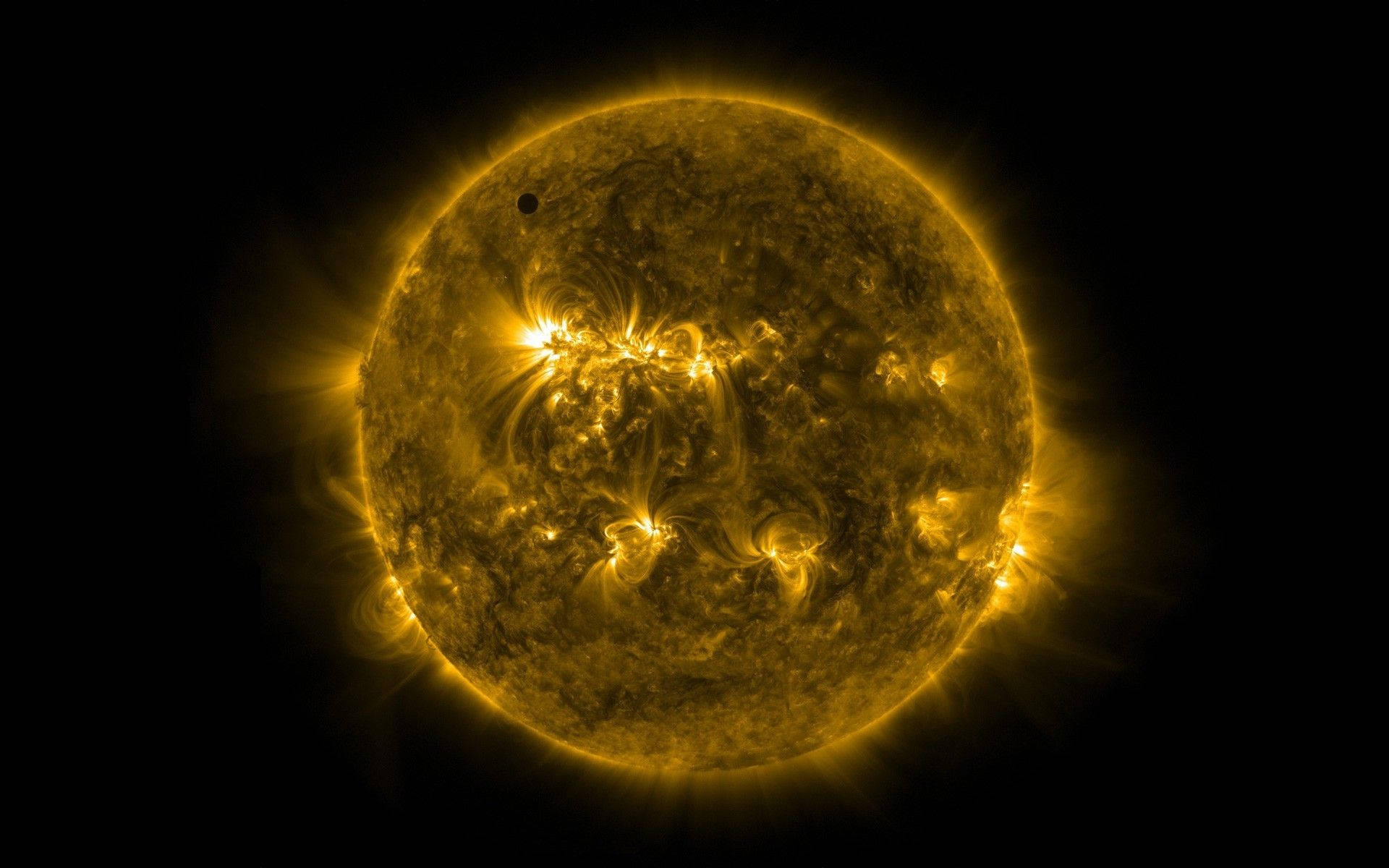 太陽系 桌布 壁紙 — 一顆熾熱的金色太陽，帶有旋轉的太陽耀斑和一顆在黑色虛空前經過的小型暗色行星。
