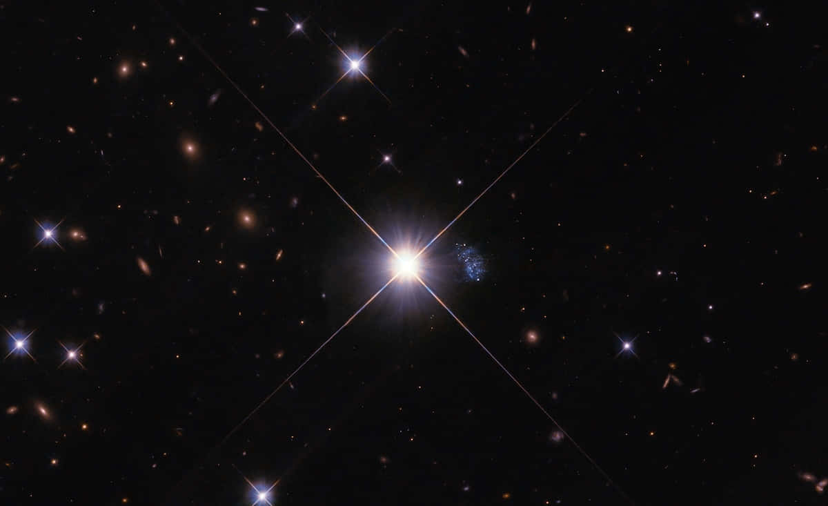 Stars 桌布 壁紙 — 一顆璀璨的星星在深邃的黑色宇宙中閃耀著光芒，宇宙中點綴著遙遠的星系和微弱的星星。