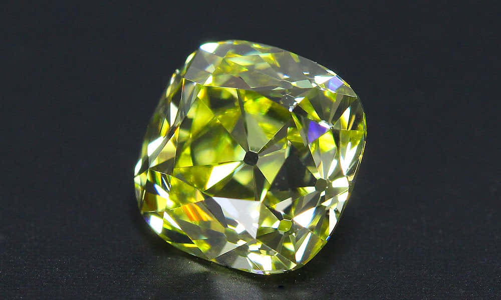 Yellow Diamond 桌布 壁紙 — 一顆璀璨的黃色枕形切割鑽石，在純黑背景上閃耀著火焰般的刻面。