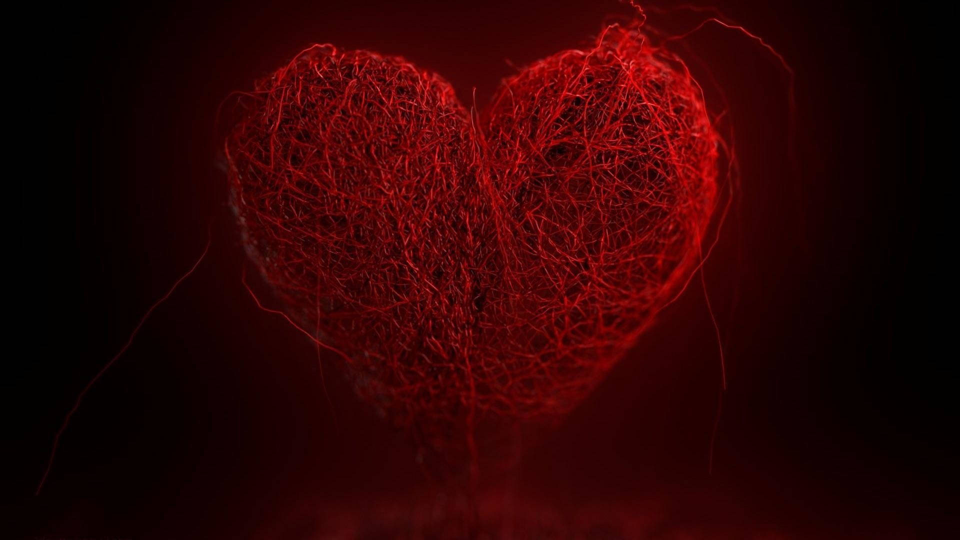 Dark Heart 桌布 壁紙 — 一顆由纏繞纖維編織而成的發光紅色心臟，在黑暗背景中跳動。